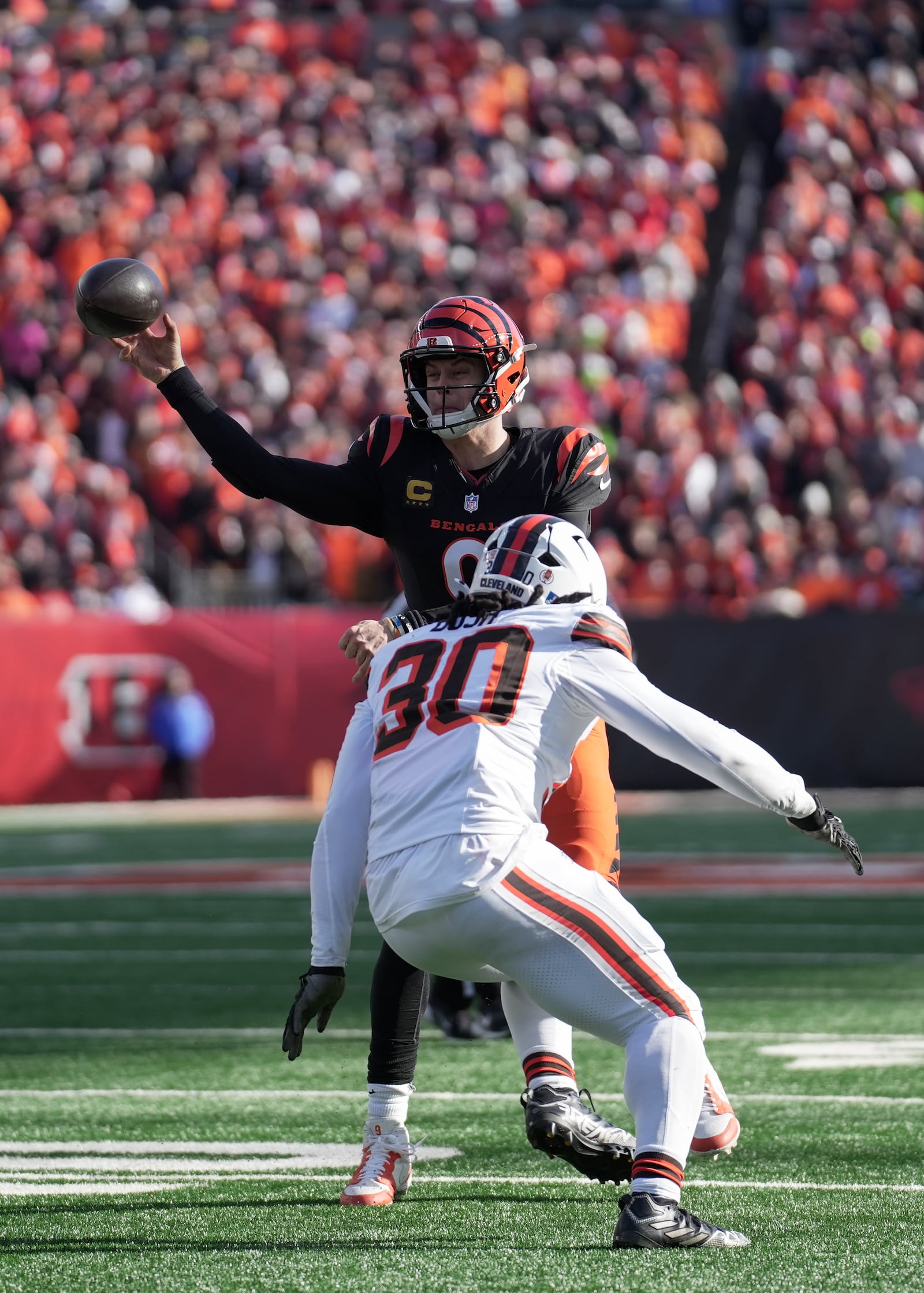 Cincinnati Bengals quarterback Joe Burrow (9) throws while under pressure from Cleveland Browns linebacker Devin Bush (30) during the first half of an NFL football game, Sunday, Dec. 22, 2024, in Cincinnati. (AP Photo/Joshua A. Bickel)