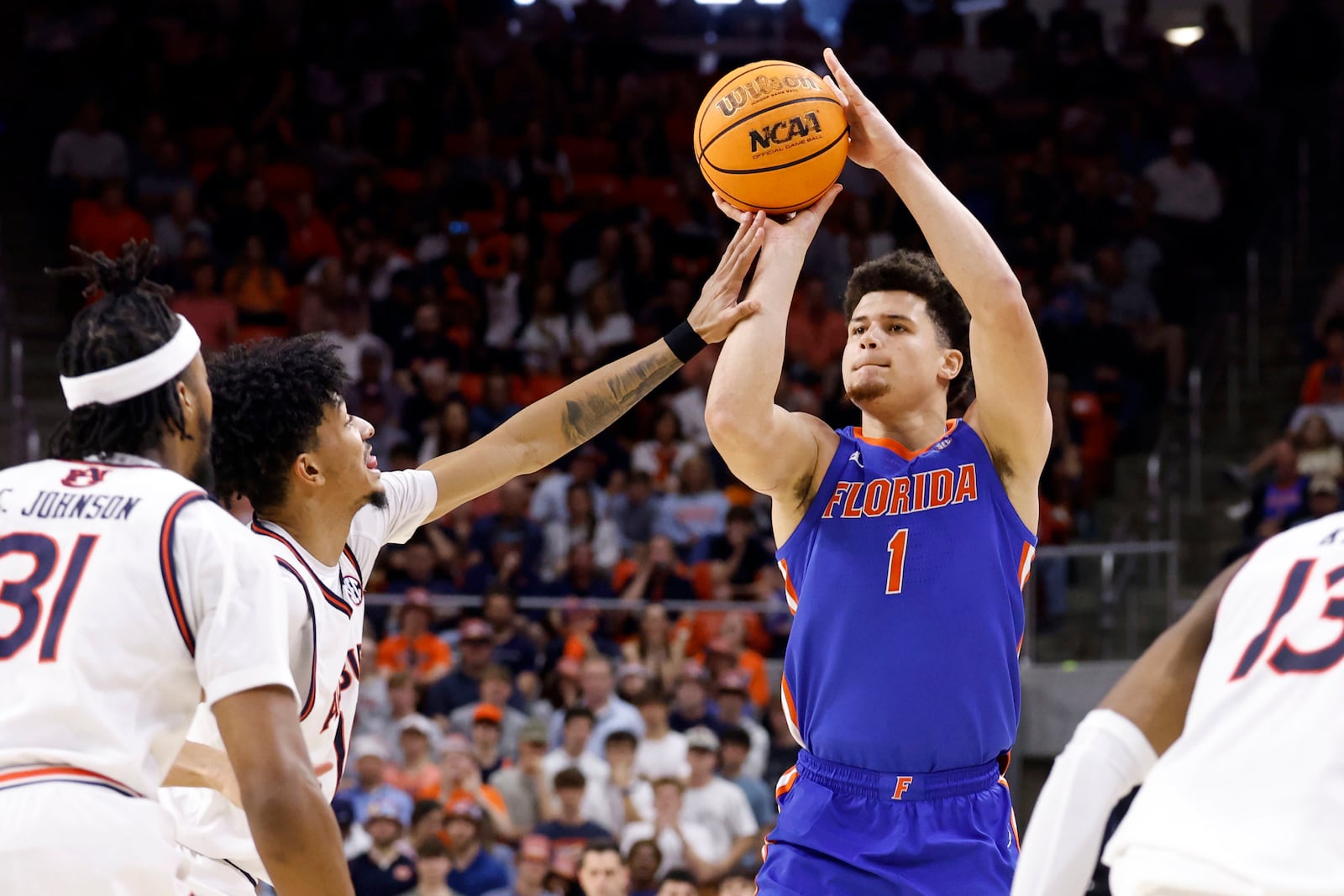 Florida guard Walter Clayton Jr. (1) is fouled by Auburn guard Chad Baker-Mazara, second from left, as he prepares to shoot a 3-point basket during the first half of an NCAA college basketball game, Saturday, Feb. 8, 2025, in Auburn, Ala. (AP Photo/Butch Dill)