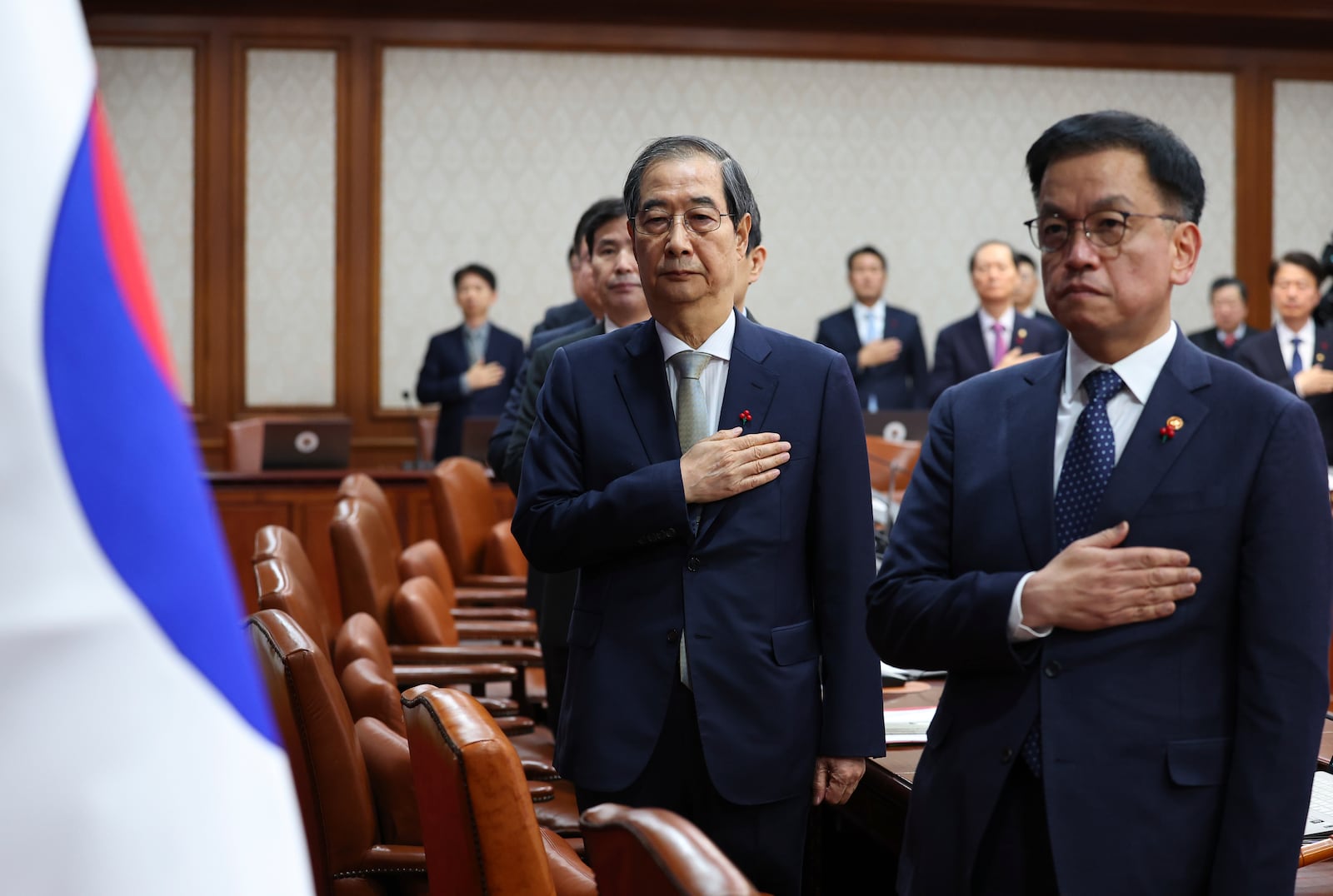 South Korea's Prime Minister Han Duck-soo, second from right, who became the country's acting leader after President Yoon Suk Yeol's impeachment, salutes during a cabinet meeting at the government complex in Seoul, South Korea, Tuesday, Dec. 24, 2024. (Yonhap via AP)