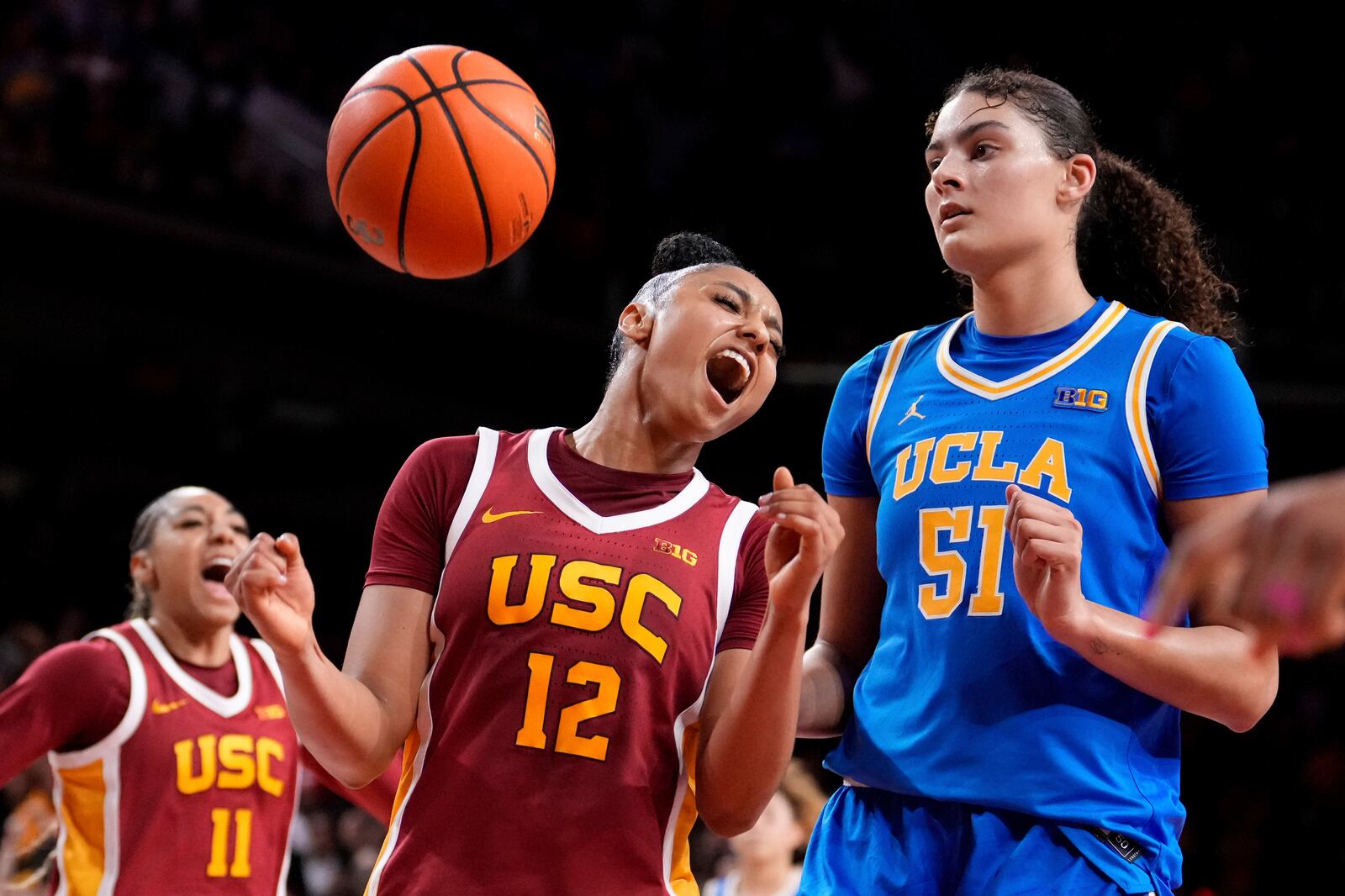 Southern California guard JuJu Watkins, center, celebrates along with guard Kennedy Smith, left, after scoring as UCLA center Lauren Betts looks on during the second half of an NCAA college basketball game, Thursday, Feb. 13, 2025, in Los Angeles. (AP Photo/Mark J. Terrill)