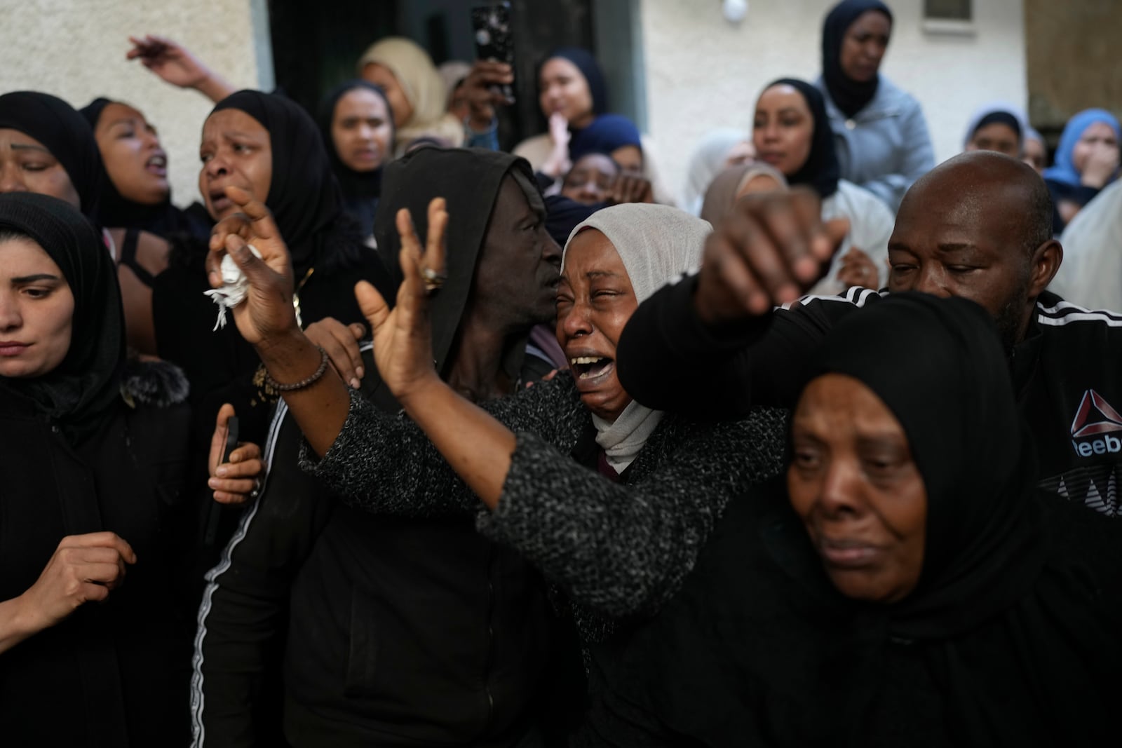 Mourners cry while they take the last look at the body of a relative, one of eight Palestinians killed, during their funeral following the withdrawal of the Israeli army, in the West Bank city of Tulkarem, Thursday, Dec. 26, 2024. (AP Photo/Matias Delacroix)