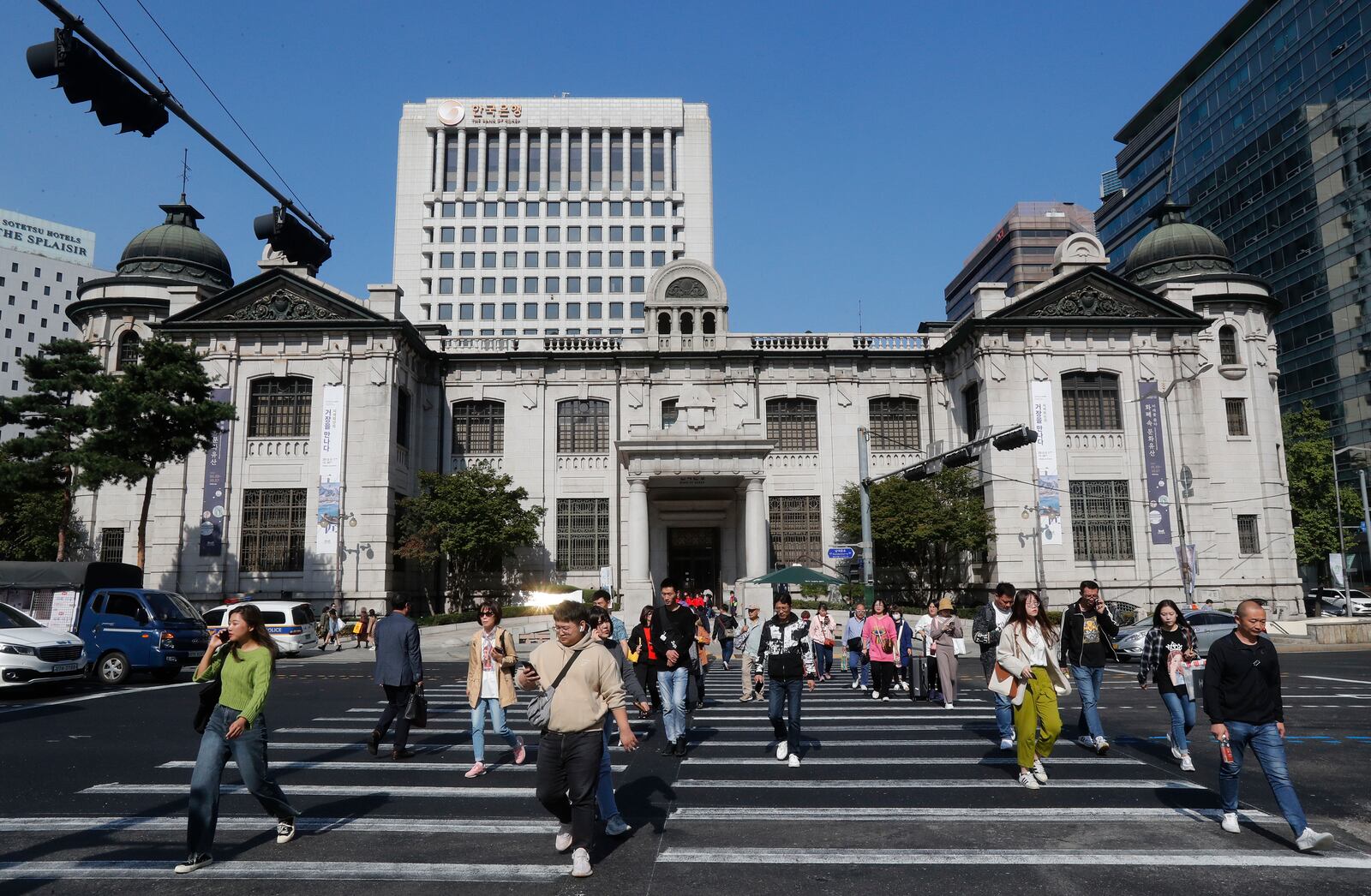 FILE - People pass by the headquarters of the Bank of Korea in Seoul, South Korea, Oct. 16, 2019. (AP Photo/Ahn Young-joon, File)