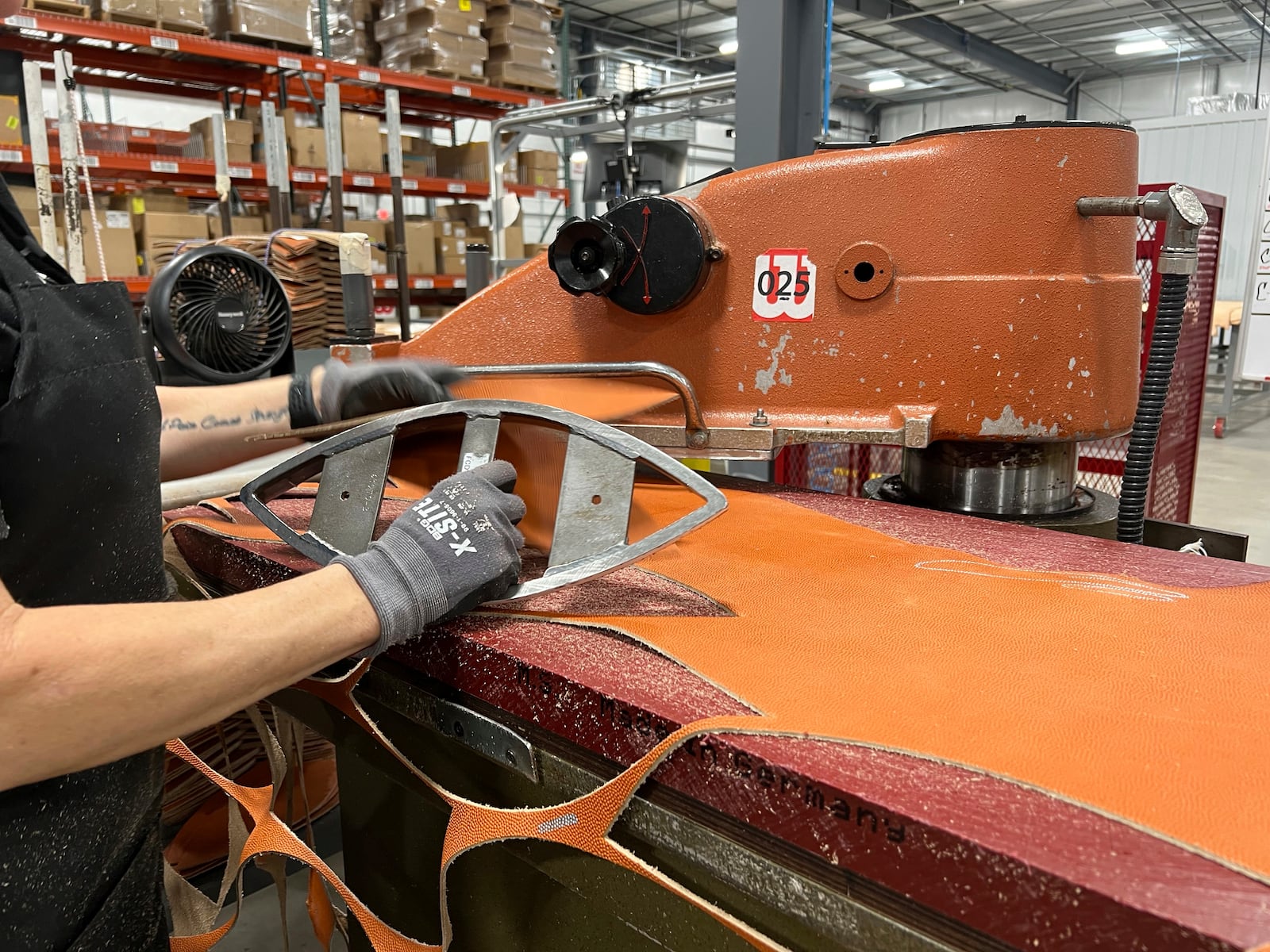 An employee uses a machine that cuts the material into a shape of a football for the upcoming Super Bowl matchup between the Philadelphia Eagles and the Kansas City Chiefs at the Wilson Sporting Goods football factory, Monday, January 27, 2025, in Ada, Ohio. (AP Photo/Patrick Aftoora-Orsagos)