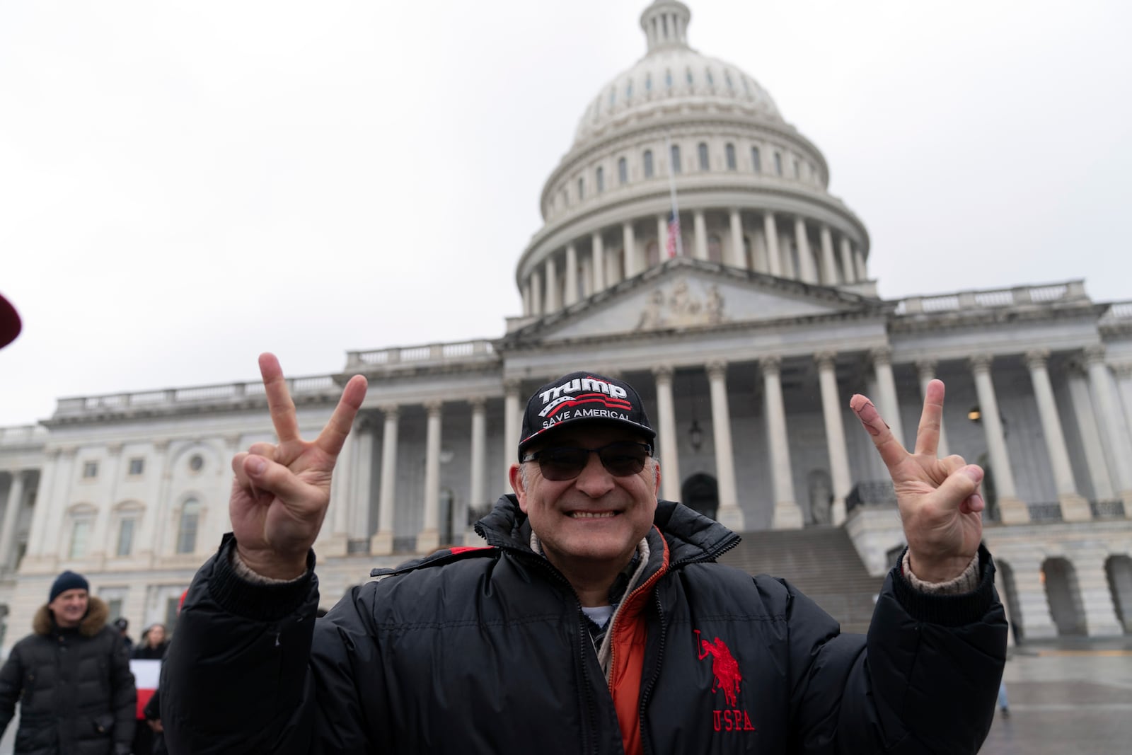 Supporter of President-elect Donald Trump Romaulad Helinski gestures as he celebrates outside of the U.S. Capitol, Sunday, Jan. 19, 2025, in Washington. (AP Photo/Jose Luis Magana)