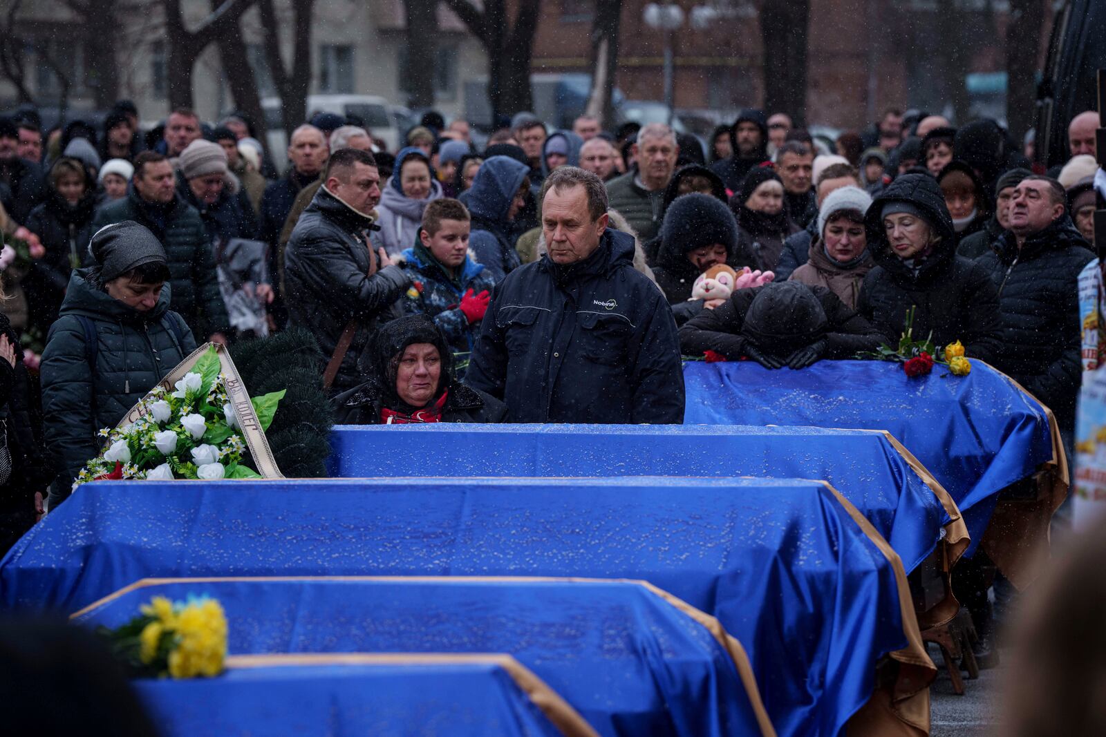 Relatives stand near coffins of Kateryna Zapishnya, 38, Diana Zapishnya, 12, Danyil Zapishnyi, 8, Serhii Zapishnyi, 40, Dmytro Yavorskyi, 37, Sofia Yavorska, 9, and Olena Yavorska 38, who were killed on Feb. 1 by a Russian strike on residential building during a funeral ceremony in Poltava, Ukraine, Wednesday, Feb. 5, 2025. (AP Photo/Evgeniy Maloletka)