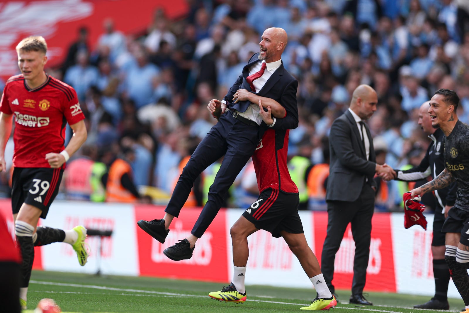 FILE - Manchester United's Lisandro Martinez lifts Manchester United's head coach Erik ten Hag while celebrating victory in the English FA Cup final soccer match between Manchester City and Manchester United at Wembley Stadium in London, Saturday, May 25, 2024. (AP Photo/Ian Walton, File)