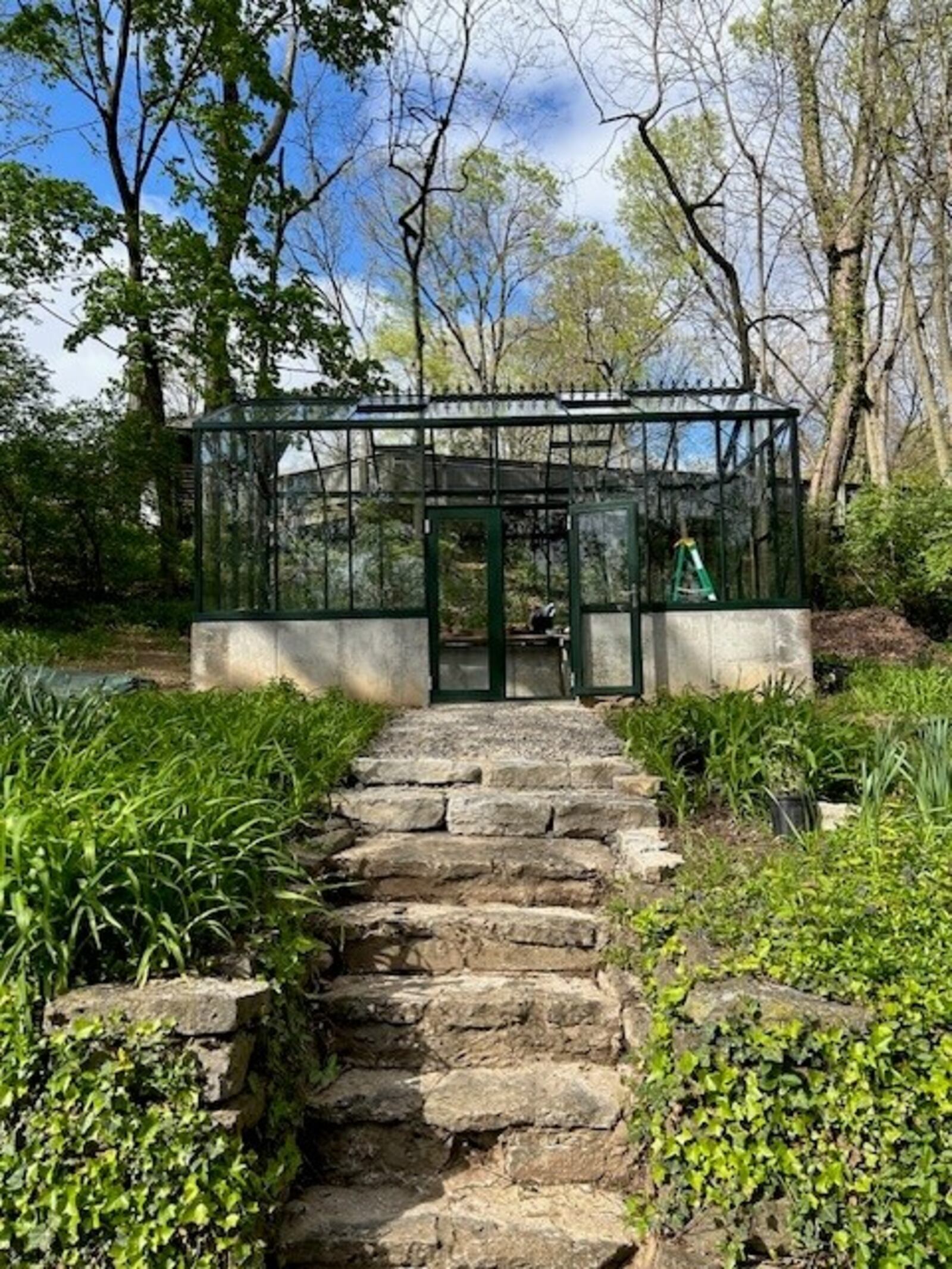 Stone steps lead up to the greenhouse, which was purchased at Costco. Sarena Kelley is adding stone around the bottom wall to give it the feel of the rest of the home and garden. JANA COLLIER/CONTRIBUTED