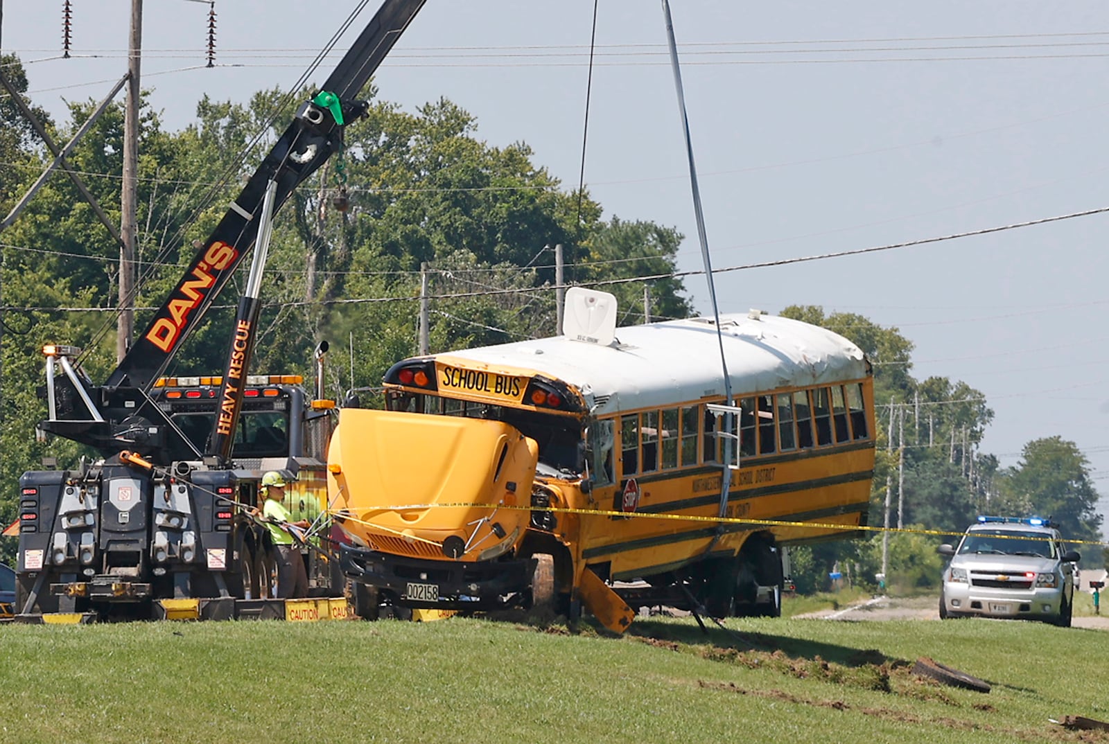 A Northwestern School District bus is uprighted by a crane after it was involved in a crash with another vehicle and rolled over. Twenty three children were transported to the hospital after the crash and one child was killed when they were ejected. BILL LACKEY/STAFF