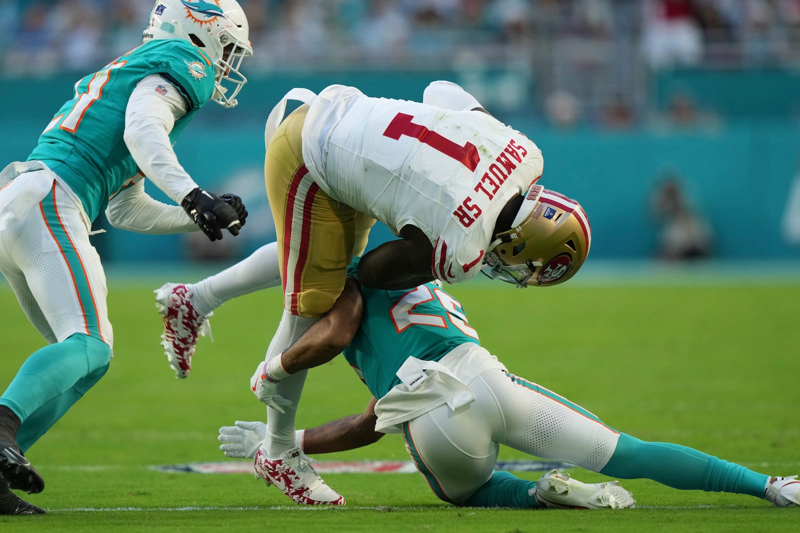 San Francisco 49ers wide receiver Deebo Samuel Sr. (1) is tackled by Miami Dolphins running back Jaylen Wright (25) during the first half of an NFL football game, Sunday, Dec. 22, 2024, in Miami Gardens, Fla. (AP Photo/Lynne Sladky)