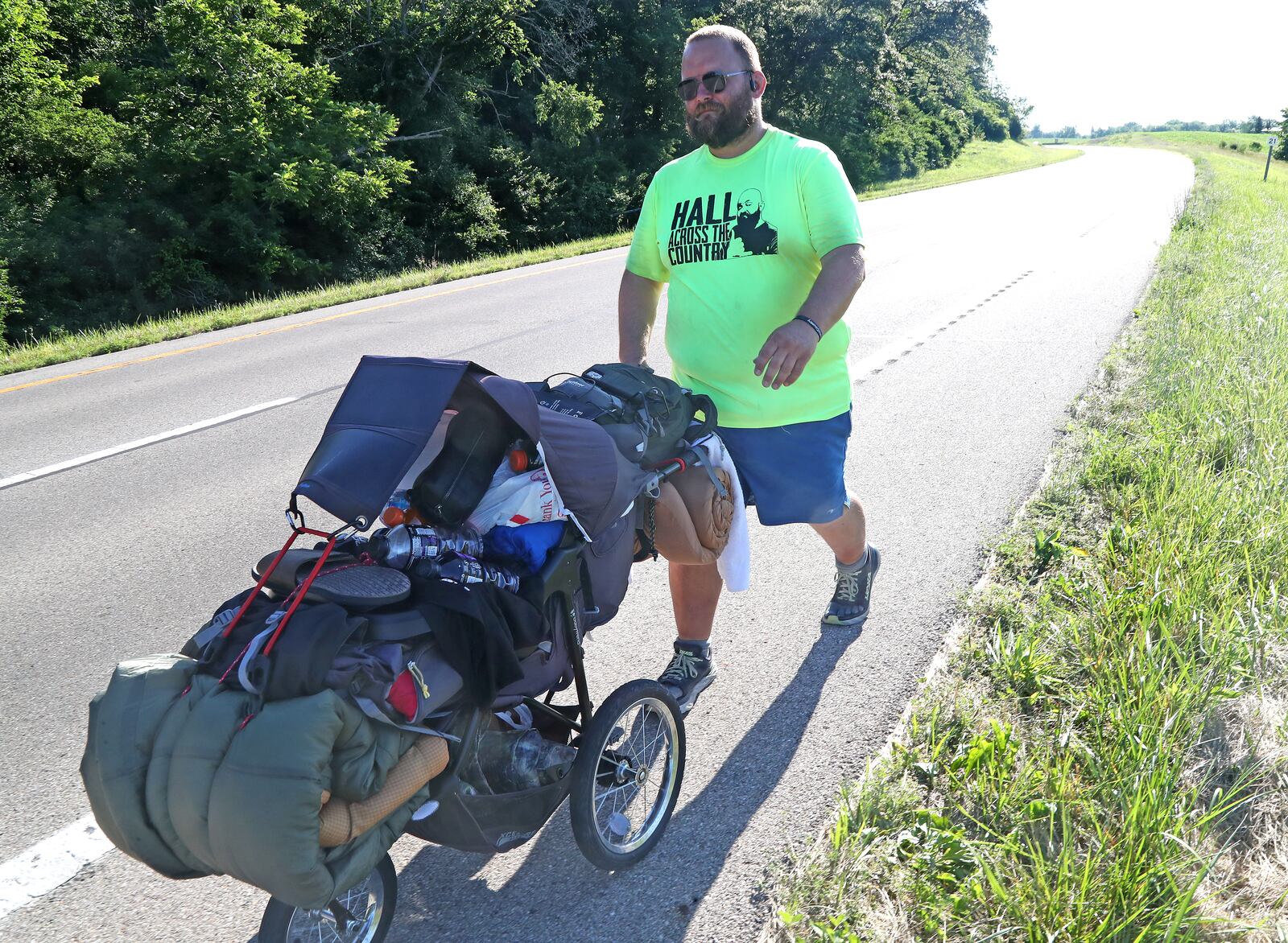 Joe Hall walks along U.S. 40 between South Vienna and Springfield on Thursday, June 23, 2022. Hall is walking across America in a fundraiser for Dayton Children's Behavioral Health Unit. BILL LACKEY/STAFF