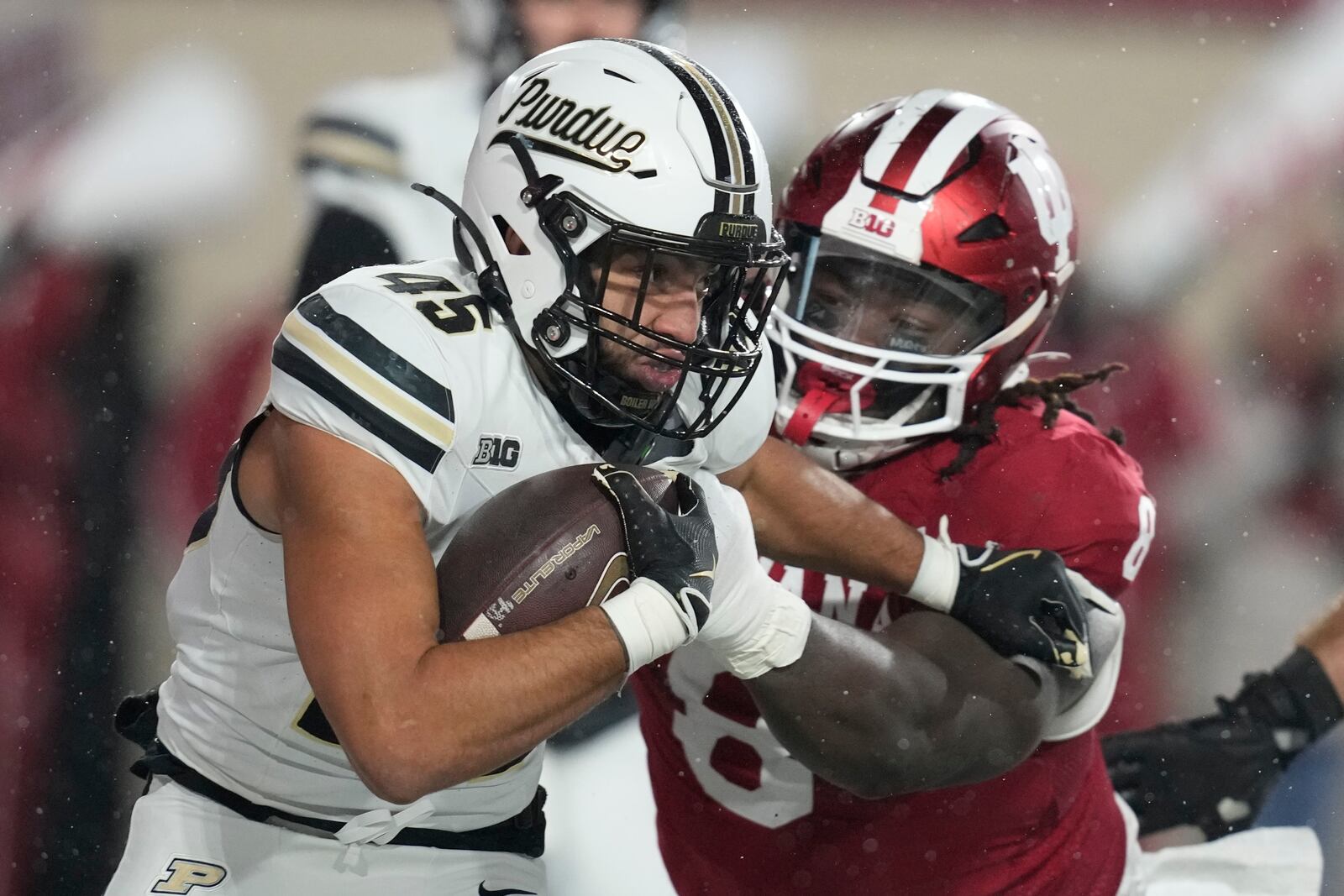 Purdue running back Devin Mockobee (45) runs out of the tackle of Indiana defensive lineman CJ West during the first half of an NCAA college football game, Saturday, Nov. 30, 2024, in Bloomington, Ind. (AP Photo/Darron Cummings)