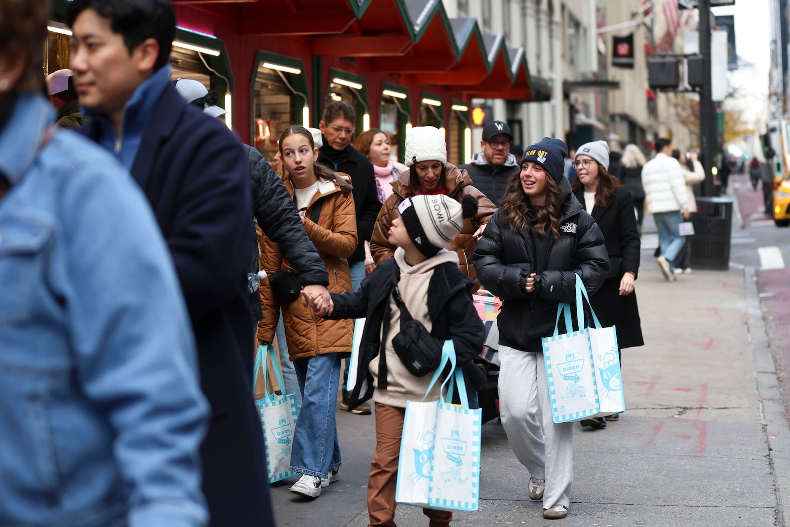 Shoppers walk along Fifth Avenue, Friday, Nov. 29, 2024, in New York. (AP Photo/Heather Khalifa)