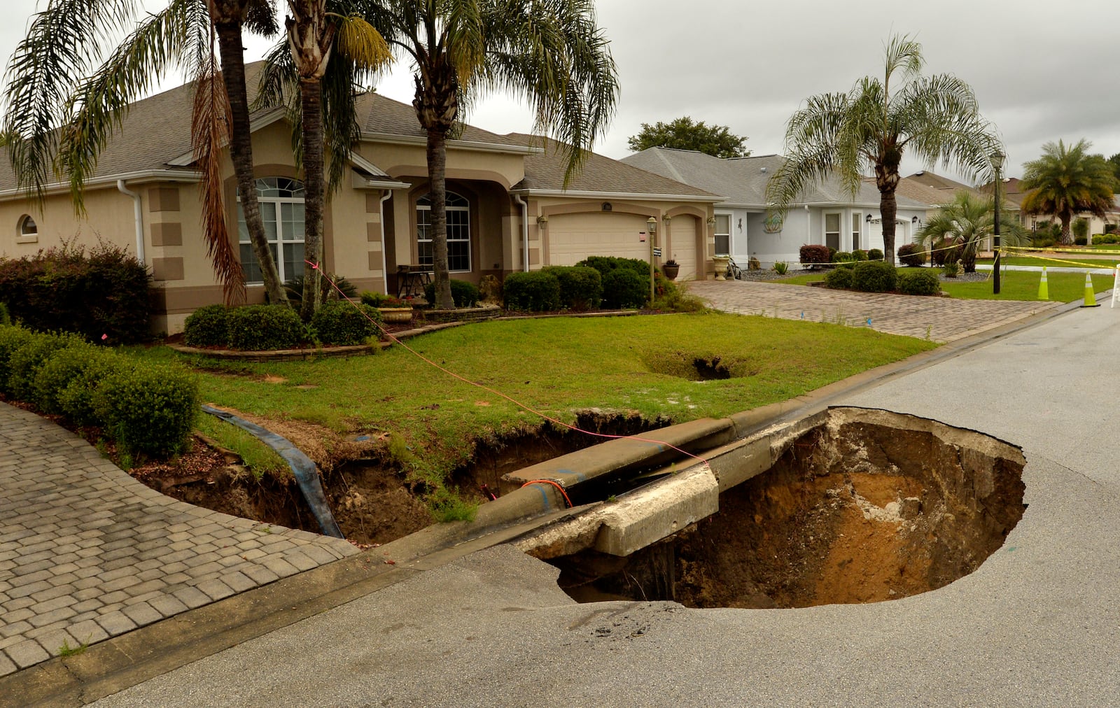 FILE - A sinkhole is shown after opening in the road at the intersection of McAlpin Street and McLawren Terrace in The Villages, Florida, on Monday, May 21, 2018. (George Horsford/Daily Sun via AP, File)