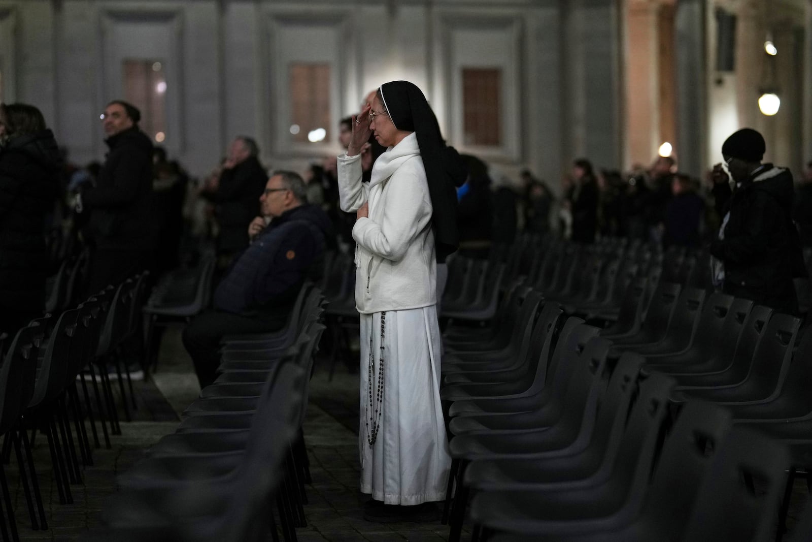 A Catholic nun crosses herself during a prayer of the Rosary for Pope Francis in St. Peter's Square at The Vatican, Sunday, March 9, 2025. (AP Photo/Francisco Seco)