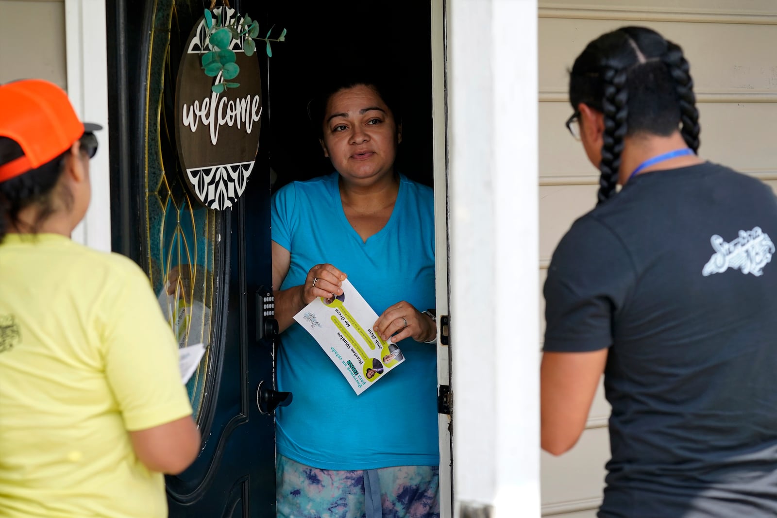 Salvador Fonseca, right, and Elena Jimenez, left, speak with Johanna Ortiz during a voter engagement event for the Latino community in Greensboro, N.C., Saturday, Sept. 21, 2024. (AP Photo/Chuck Burton)