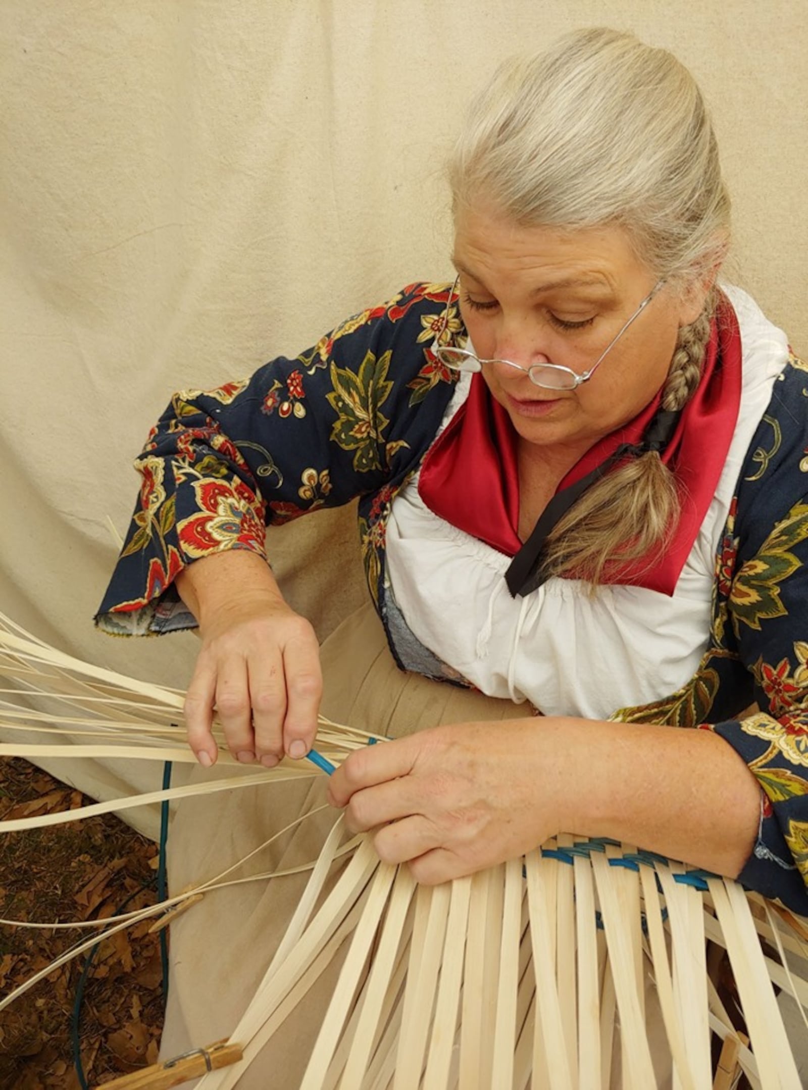 Wearing the proper clothing for the time period, Margaret Bickenheuser works on a basket at an event. CONTRIBUTED