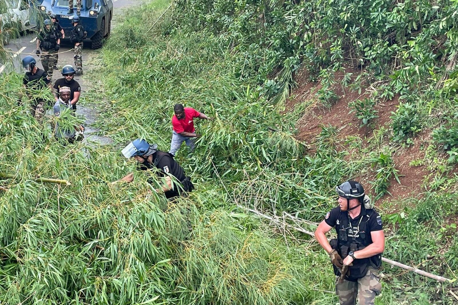 This photo provided Monday, Dec.16, 2024 by the Gendarmerie Nationale shows French Gendarmes clearing a road, Sunday, Dec. 15, 2024 in Mayotte as France rushed rescue teams and supplies to its largely poor overseas department in the Indian Ocean that has suffered widespread destruction. (Gendarmerie Nationale via AP)