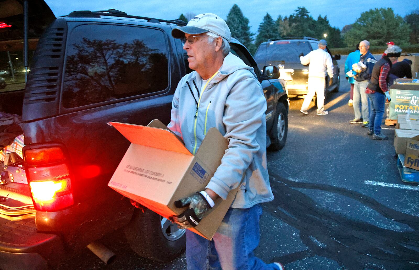 Brian Cox loads a car at the Second Harvest Food Bank food distribution at Clark State Monday, Nov. 6, 2023. BILL LACKEY/STAFF