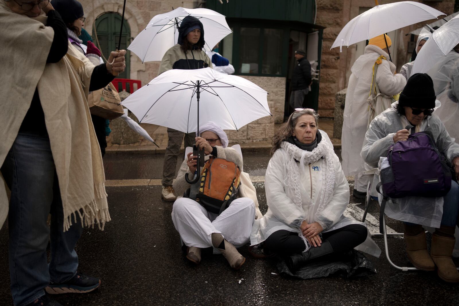 Women Mishmeret 101, or shift 101, a group of mothers of hostages held in the Gaza Strip and their supporters, take part in a silent sit-in at the U.S. Consulate building that houses the Office of Palestinian Affairs in Jerusalem to urge the government to complete all phases of the hostage deal to bring everyone home, Friday, Feb. 7, 2025. (AP Photo/Maya Alleruzzo)