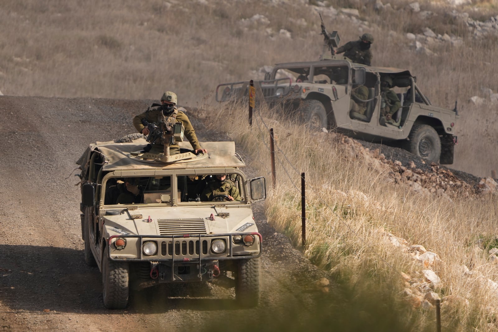 Israeli soldiers stand on armoured vehicles inside the buffer zone near the so-called Alpha Line that separates the Israeli-controlled Golan Heights from Syria, viewed from the town of Majdal Shams, Saturday, Dec. 21, 2024. (AP Photo/Matias Delacroix)