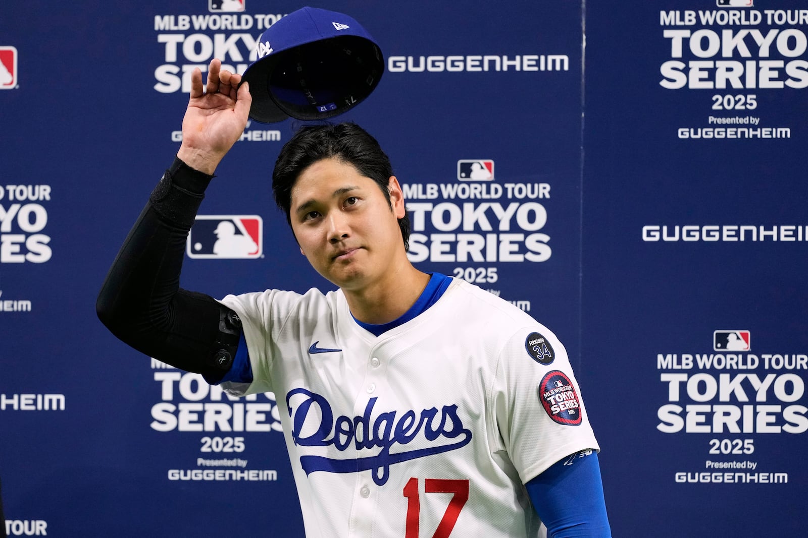 Los Angeles Dodgers' Shohei Ohtani tips his cap to fans after giving an interview following the team's win agianst the Chicago Cubs in an MLB Tokyo Series baseball game in Tokyo, Japan, Wednesday, March 19, 2025. (AP Photo/Hiro Komae)