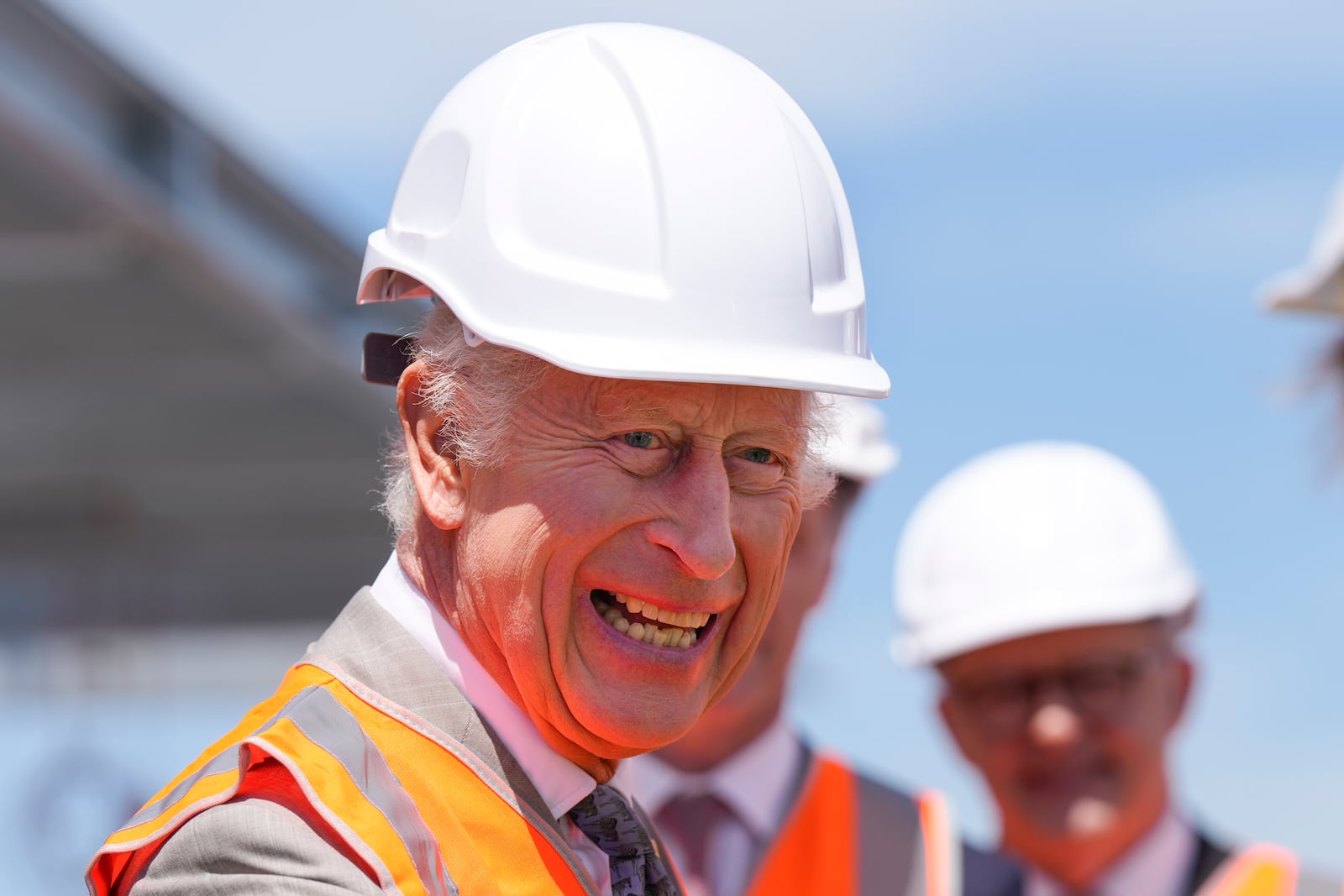 Britain's King Charles III wears a protective hat as he visits the Homes NSW Cowper Street development in Sydney, Australia, Tuesday, Oct. 22, 2024. (AP Photo/Mark Baker, Pool)