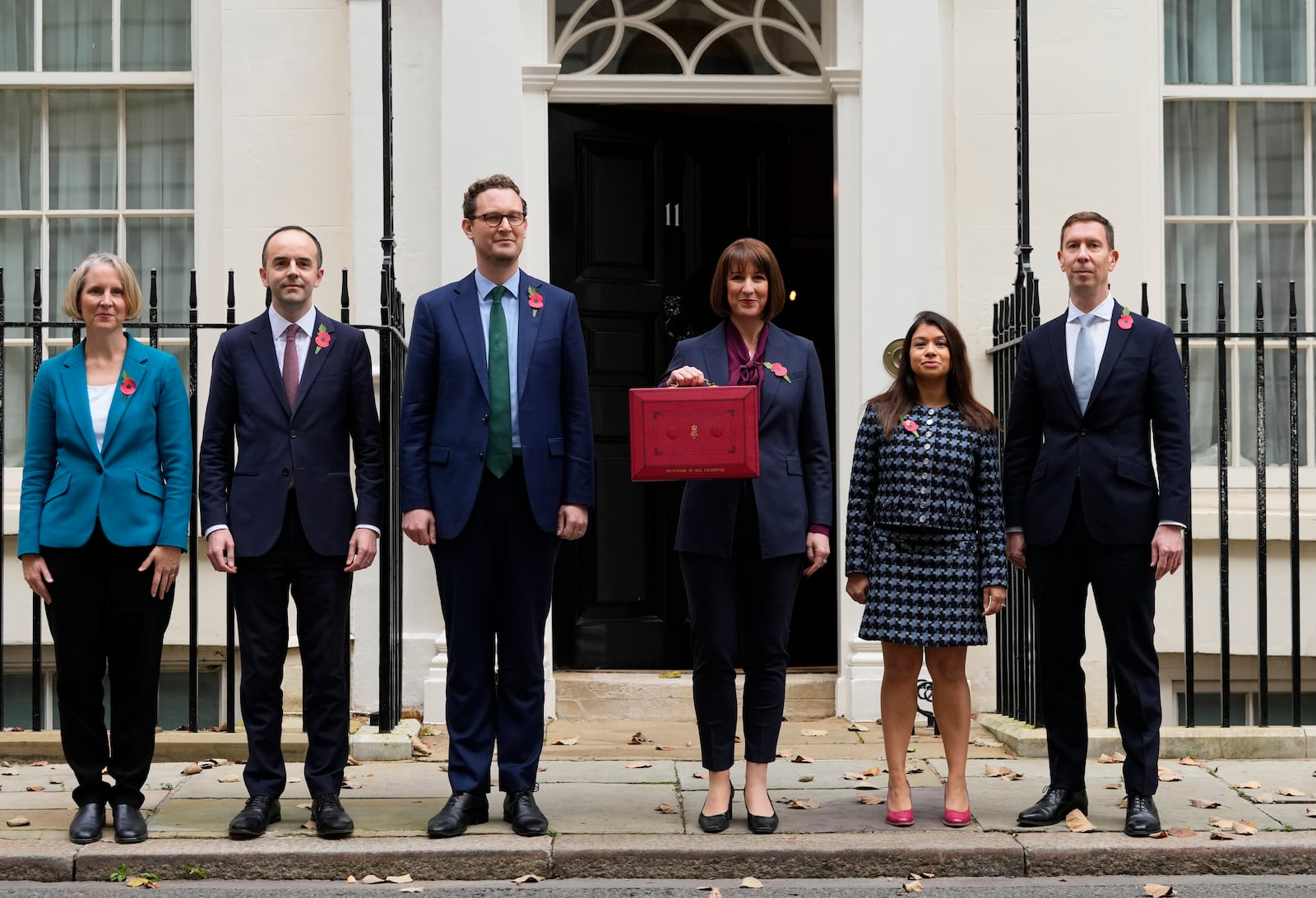 Britain's Chancellor of the Exchequer, Rachel Reeves, third right, holds up the traditional red ministerial box containing her budget speech, as she poses for the media with her ministerial team, outside No 11 Downing Street, before departing to the House of Commons to deliver the budget in London, Wednesday, Oct. 30, 2024. (AP Photo/Kirsty Wigglesworth)