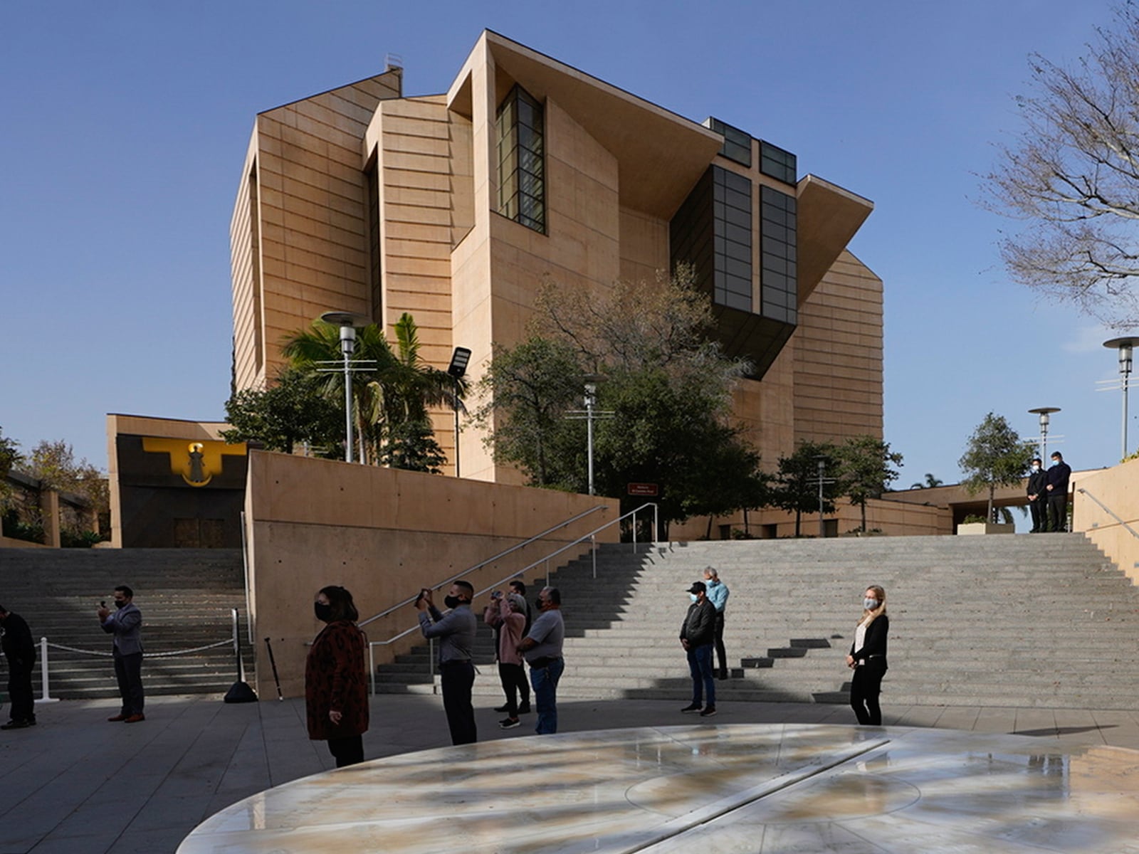 FILE - People attend a memorial service outside the Cathedral of Our Lady of Angels in Los Angeles Tuesday, Jan. 19, 2021. (AP Photo/Damian Dovarganes, File)