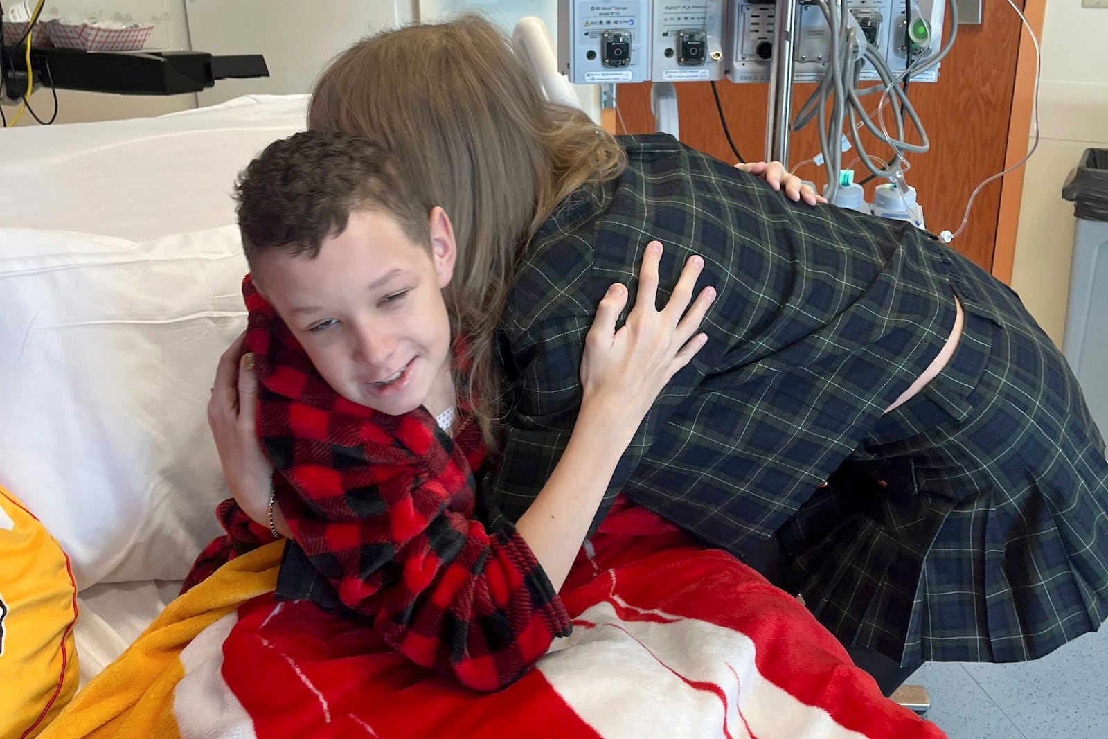 In this image provided by Cassie Thomas, Beckett Thomas, 13, who is a patient at Children's Mercy Hospital in Kansas City, Mo., is hugged by Taylor Swift, Thursday, Dec. 12, 2024. (Cassie Thomas via AP)