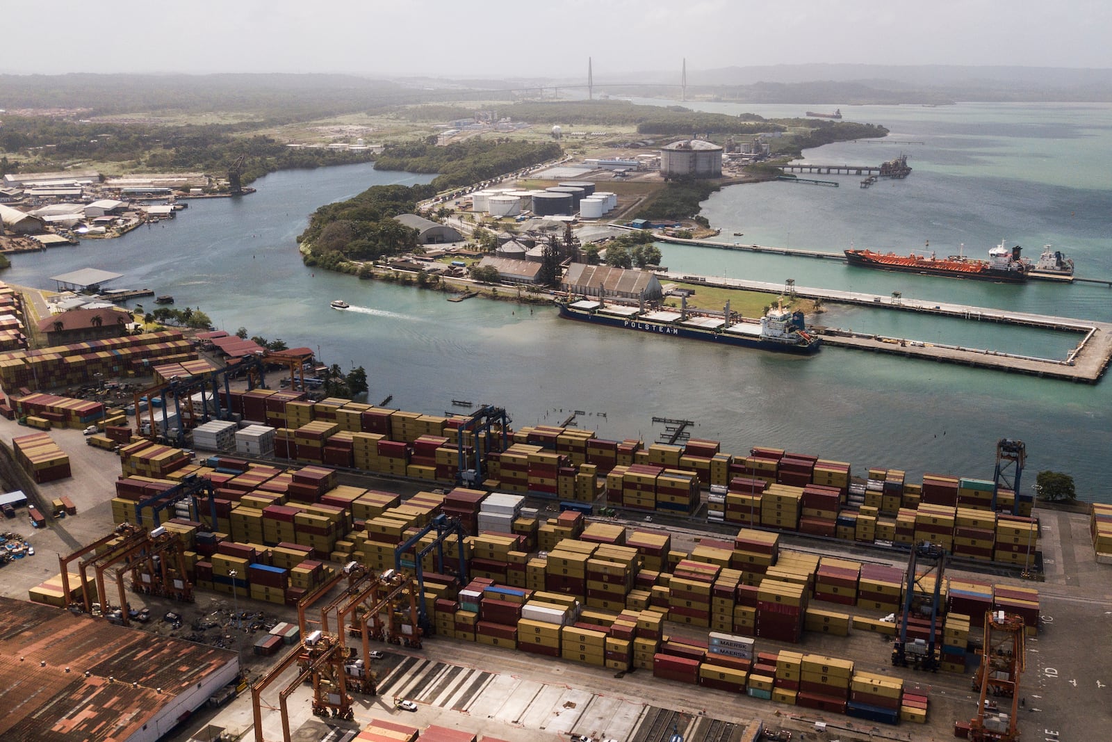 FILE - Cargo containers sit stacked as cranes load and unload containers from cargo ships at the Cristobal port, operated by the Panama Ports Company, in Colon, Panama, Feb. 4, 2025. (AP Photo/Matias Delacroix, File)