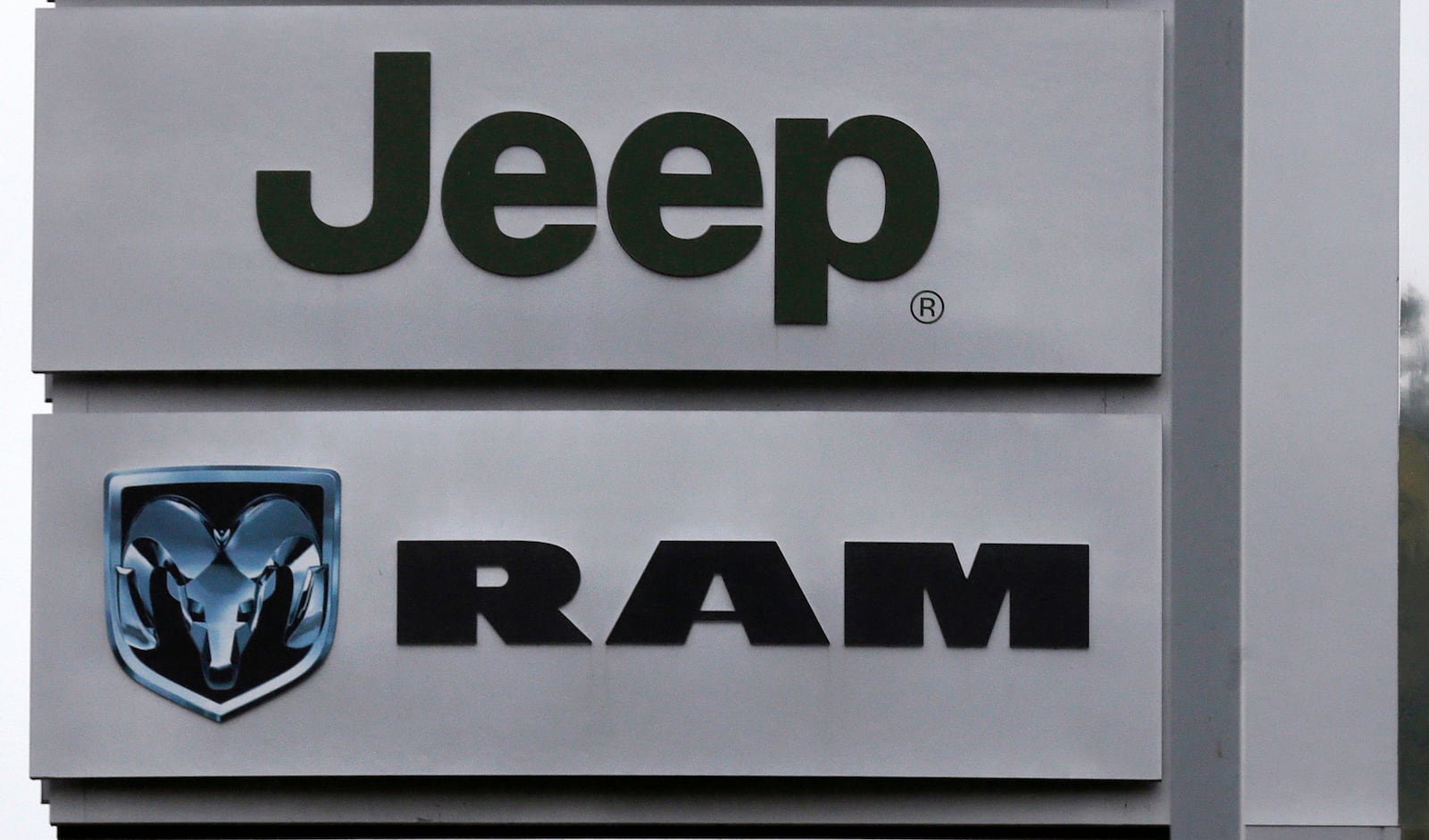 This Oct. 1, 2014 photo shows Jeep and Dodge Ram logos on signs at a dealership in Haverhill, Mass. (AP Photo/Charles Krupa, file)