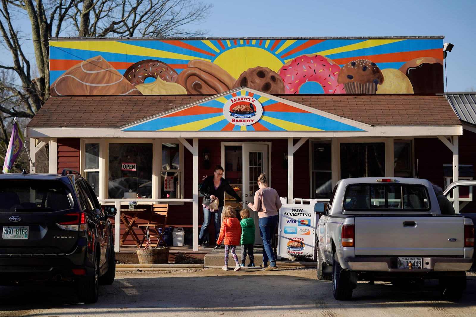 FILE - A customer holds the door for a family arriving at Leavitt's Country Bakery in this April 13, 2023 file photo, in Conway, N.H. (AP Photo/Robert F. Bukaty, file)