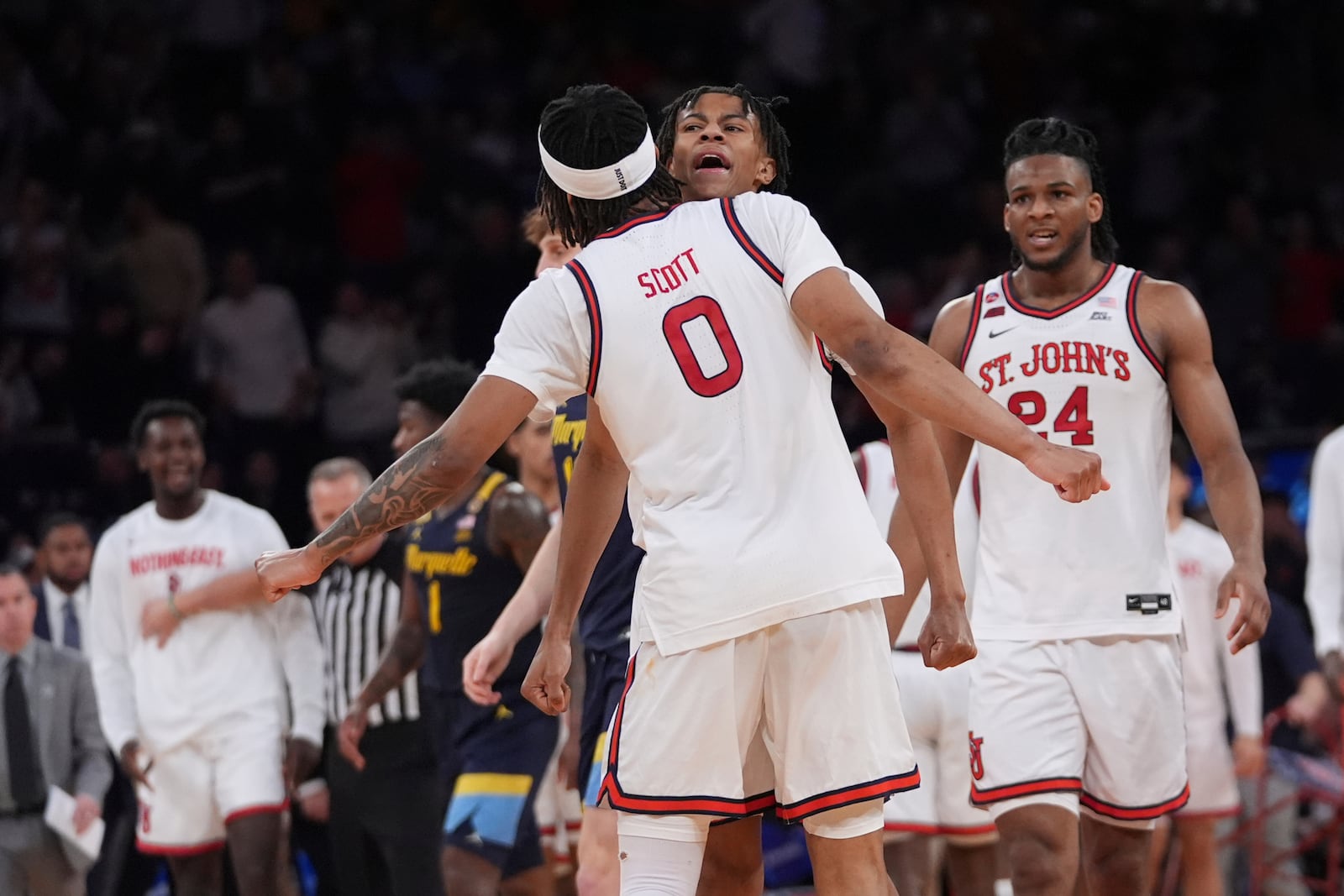 St. John's's Aaron Scott (0) celebrates with Simeon Wilcher and Zuby Ejiofor (24) during the second half of an NCAA college basketball game against the Marquette in the semifinals of the Big East tournament Friday, March 14, 2025, in New York. (AP Photo/Frank Franklin II)