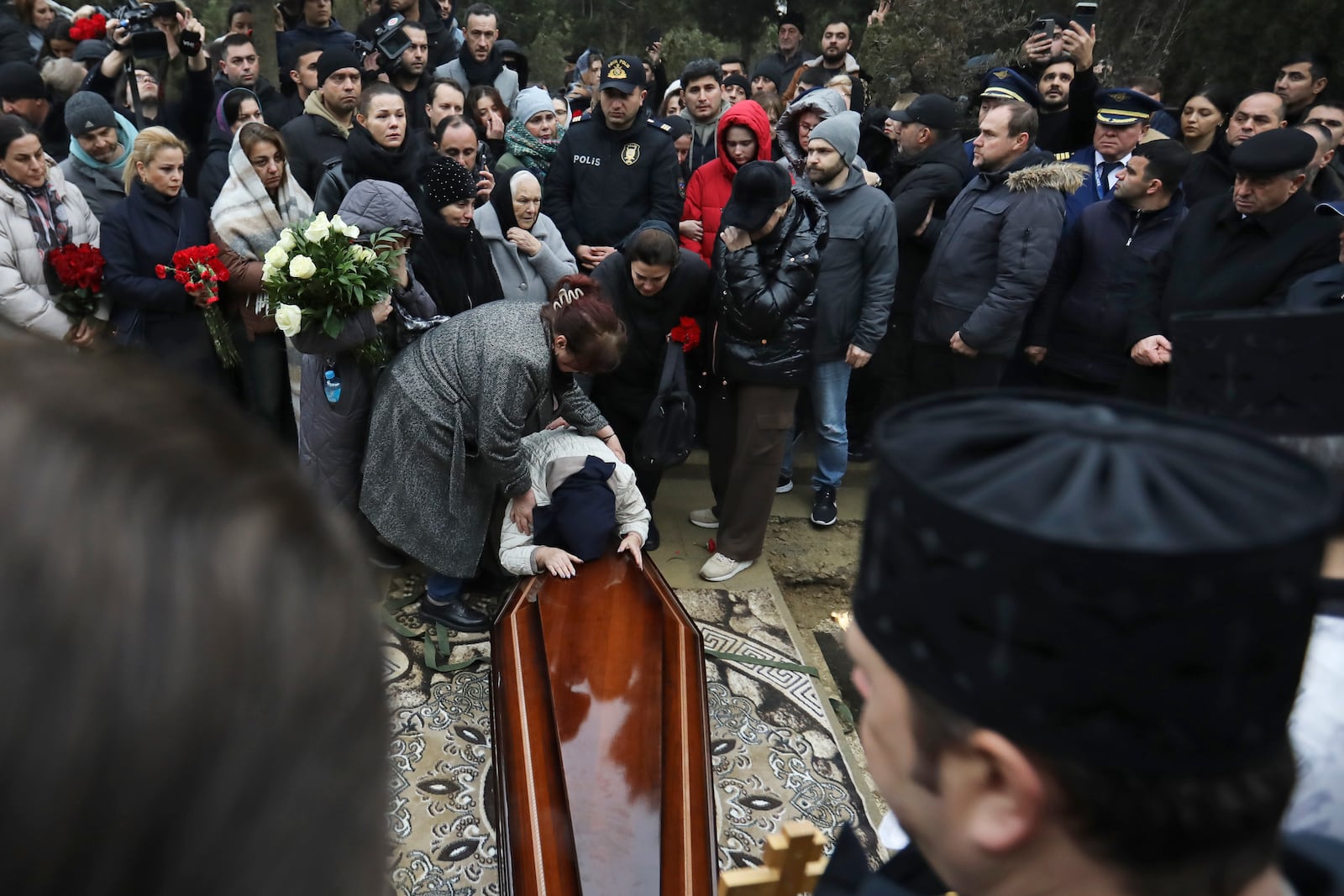 Yana Kshnyakina, widow of pilot in command Igor Kshnyakin mourns during a funeral of crew members of the Azerbaijan Airlines Embraer 190 killed in a deadly plane crash in Kazakhstan this week, at the II Alley of Honor in Baku, Azerbaijan, Sunday, Dec. 29, 2024. (AP photo)