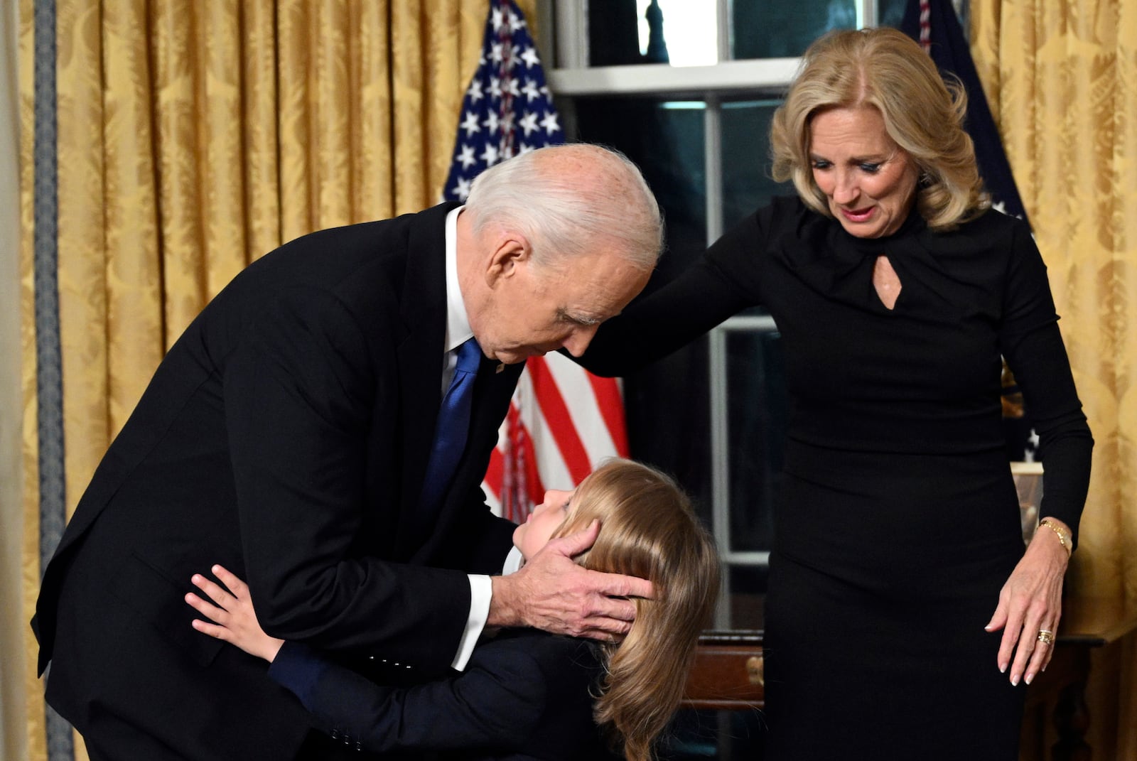 President Joe Biden hugs grandson Beau Biden as first lady Jill Biden watches after he gave his farewell address from the Oval Office of the White House Wednesday, Jan. 15, 2025, in Washington. (Mandel Ngan/Pool via AP)