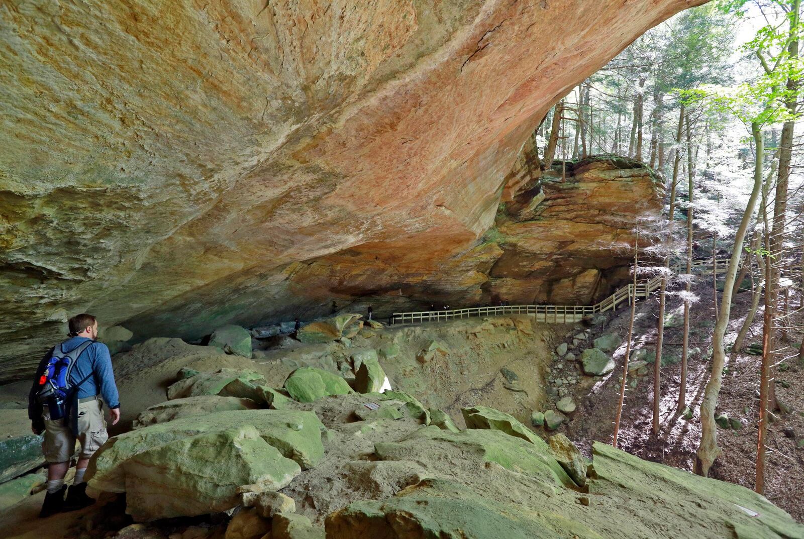 Visitors explore a natural amphitheater cut out of sandstone by a 105-foot waterfall, a highlight on Whispering Cave trail, during the inaugural hike of the new Hemlock Bridge Trail at Hocking Hills State Park near Logan on Monday, May, 8, 2017. This is the first new trail system opened at the Hocking Hills State Park in the last 50 years. More than 150 volunteers helped put in steps, cut down trees and haul stone to open the old trail back up after a 30 to 50-year hiatus. [Barbara J. Perenic/Dispatch]