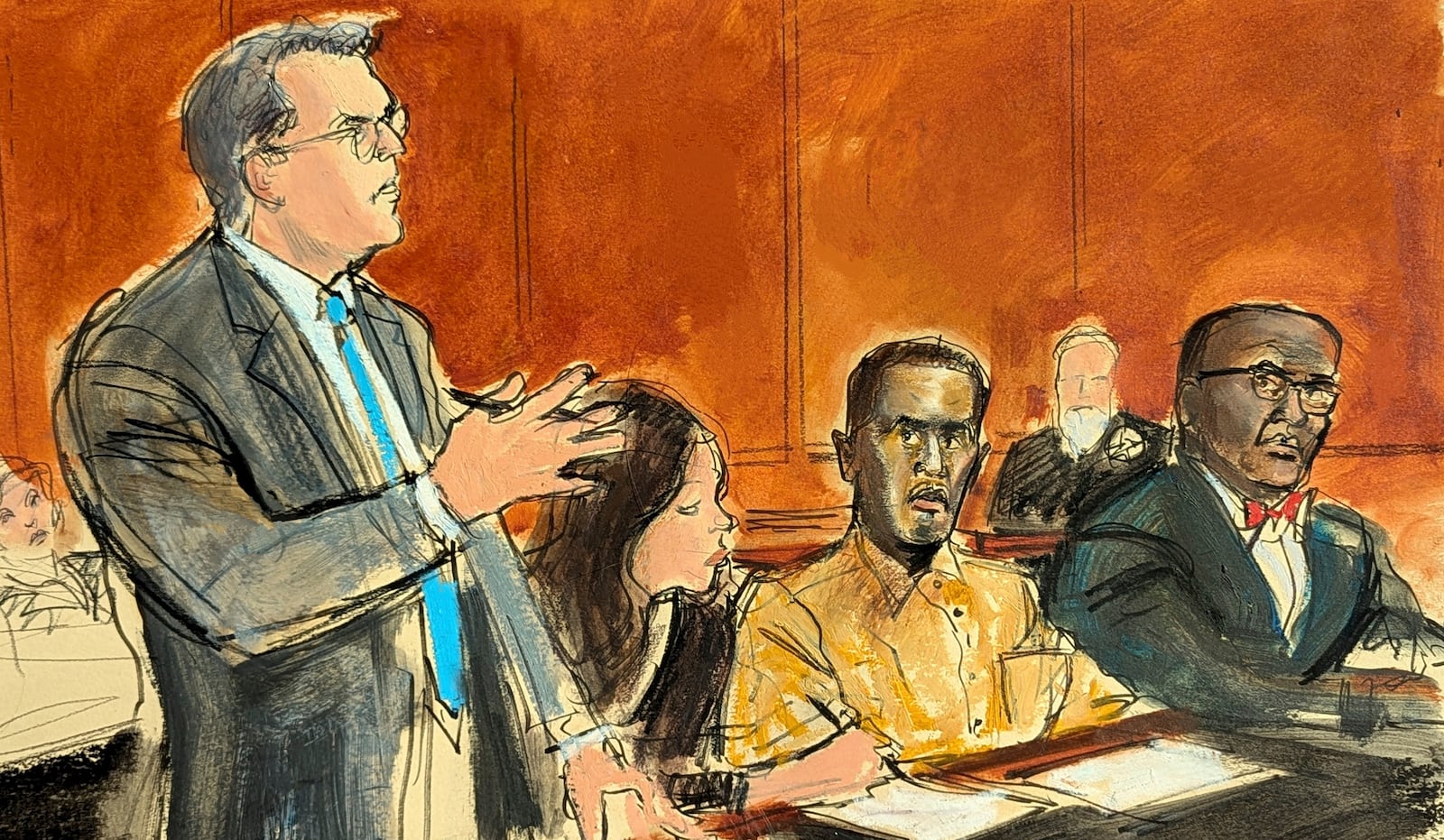 In this courtroom sketch, Sean "Diddy" Combs defense attorney Marc Agnifilo, left, addresses the judge while Combs, seated second from right, in prison uniform, watches in Federal court, in New York, Thursday, Oct. 10, 2024. Combs' new defense attorney, Anthony Ricco is seated far right. (Elizabeth Williams via AP)