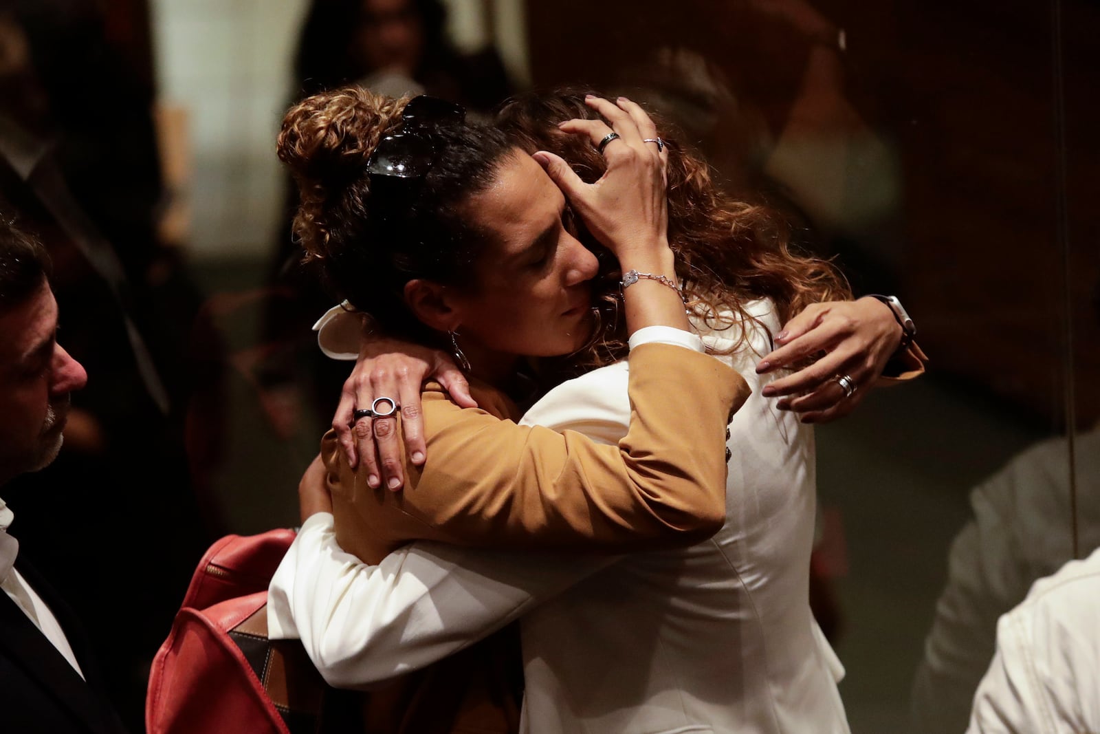 The sister, left, and widow of slain councilwoman Marielle Franco embrace after a judge sentenced two former police officers for the 2018 murder of Franco and her driver Anderson Gomes, at the Court of Justice in Rio de Janeiro, Thursday, Oct. 31, 2024. (AP Photo/Bruna Prado)