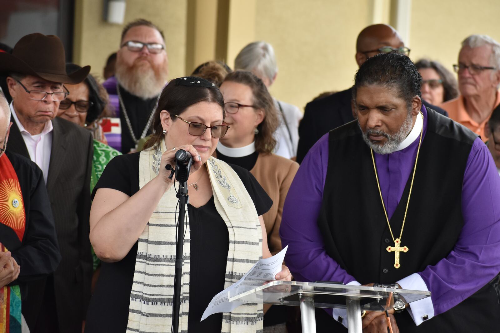 Rabbi Karen Bodney-Halasz (front left) of Temple Israel in Dayton and  Bishop William J. Barber, II, president of Repairers of the Breach, an interfaith advocacy group from North Carolina, speak to a crowd of a couple hundred people during a prayer vigil held Sunday, Sept. 22, 2024, at Greater Grace Temple in Springfield. Barber was the main speaker of the event, encouraging people and politicians not to spread false claims about Haitians, but instead, to be welcoming to immigrants. SAM WILDOW\STAFF