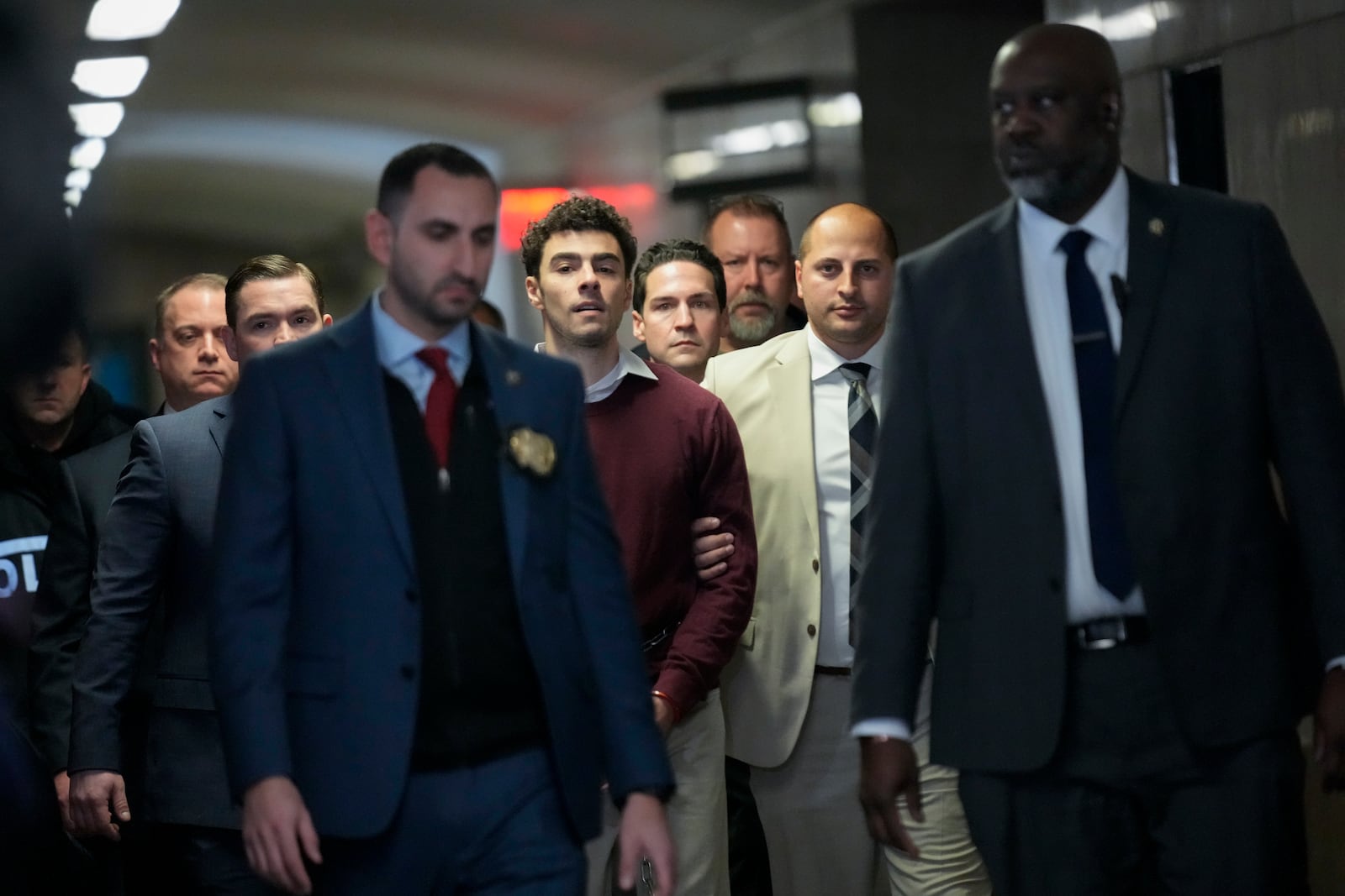 Luigie Mangione, center, is escorted into Manhattan Criminal court for his arraignment in the killing of UnitedHealthcare CEO Brian Thompson, Monday, Dec. 23, 2024, in New York. (AP Photo/Seth Wenig)