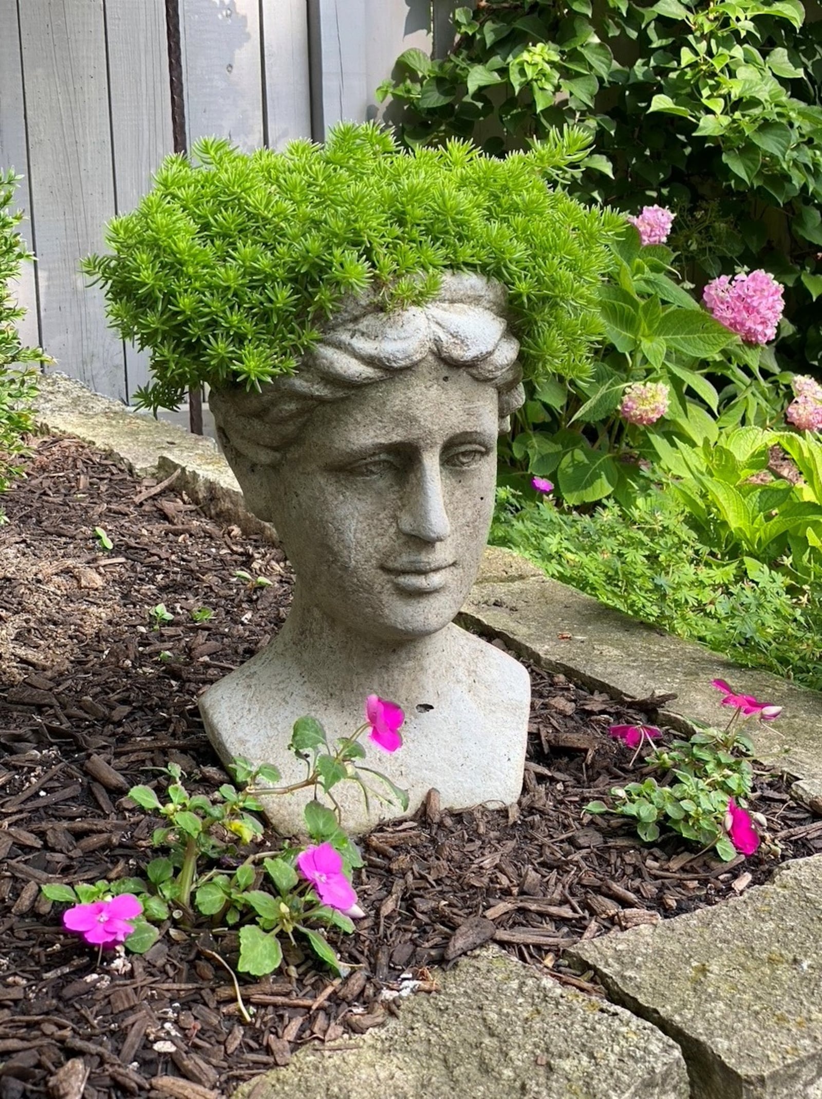 Each garden holds surprises, large and small. This sculptural stone planter is tucked among the hydrangeas. CONTRIBUTED