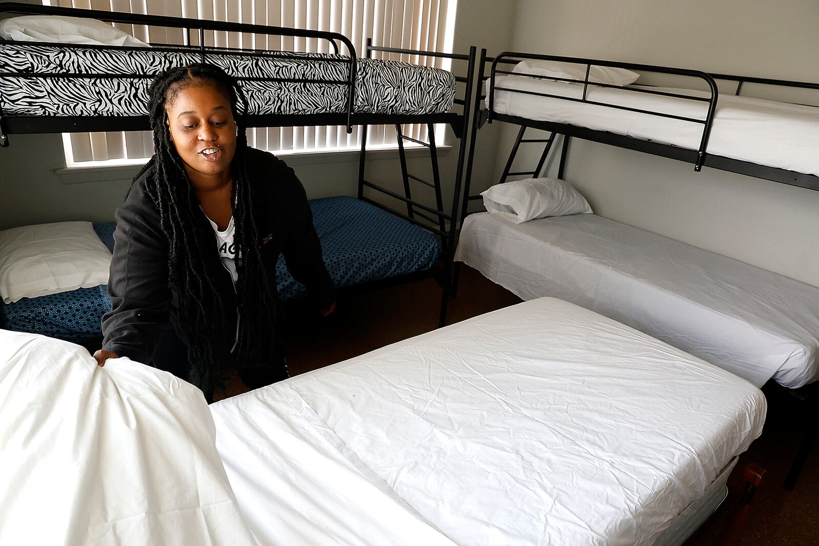 Taylor Cobb makes the beds in one of the family size rooms Tuesday, Sept. 5, 2023 as she helps get Norm's Place homeless shelter ready to reopen. BILL LACKEY/STAFF