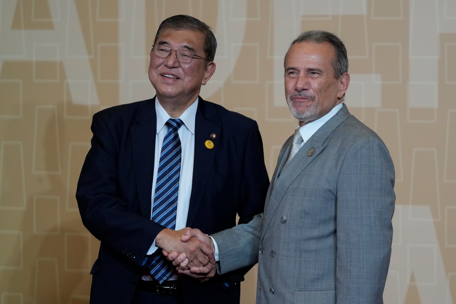 Peru's Foreign Affairs Minister Elmer Schialer, right, welcomes Japan's Prime Minister Shigeru Ishiba to the Asia-Pacific Economic Cooperation (APEC) leaders meeting in Lima, Peru, Saturday, Nov. 16, 2024. (AP Photo/Fernando Vergara)