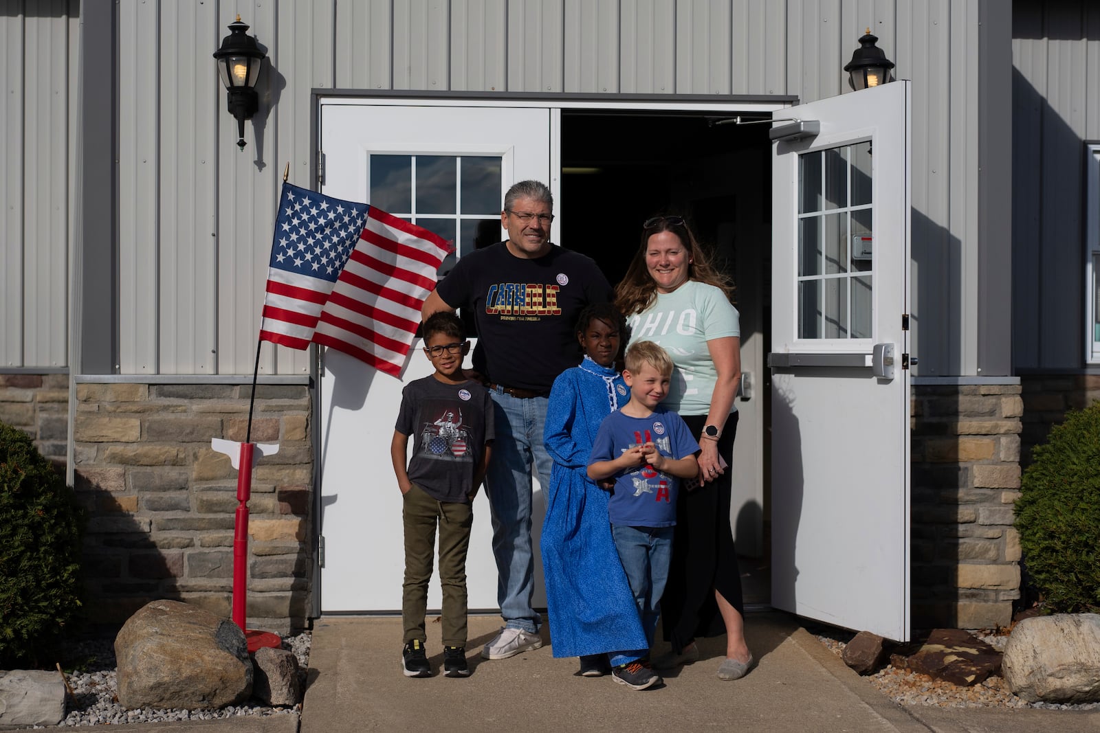 Mike and Erin Young and their three adopted kids from left, Lucas, 8, Gianna, 7, and Isaac, 5, pose for a family photo outside the Trenton Township polling place after Mike voted for Donald Trump on Election Day, Tuesday, Nov. 5, 2024, in Sunbury, Ohio. (AP Photo/Carolyn Kaster)