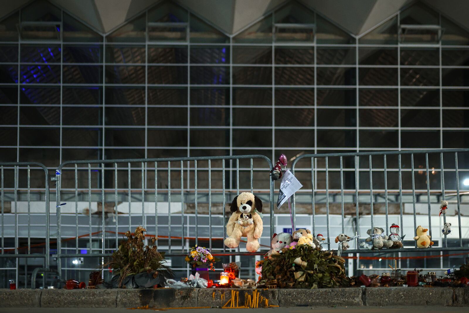 Toys, candles, flowers and a paper that reads "It shouldn't have happened here" are placed at the site the collapse of a concrete canopy that killed 15 people more than two months ago, in Novi Sad, Serbia, Friday, Jan. 31, 2025. (AP Photo/Armin Durgut)