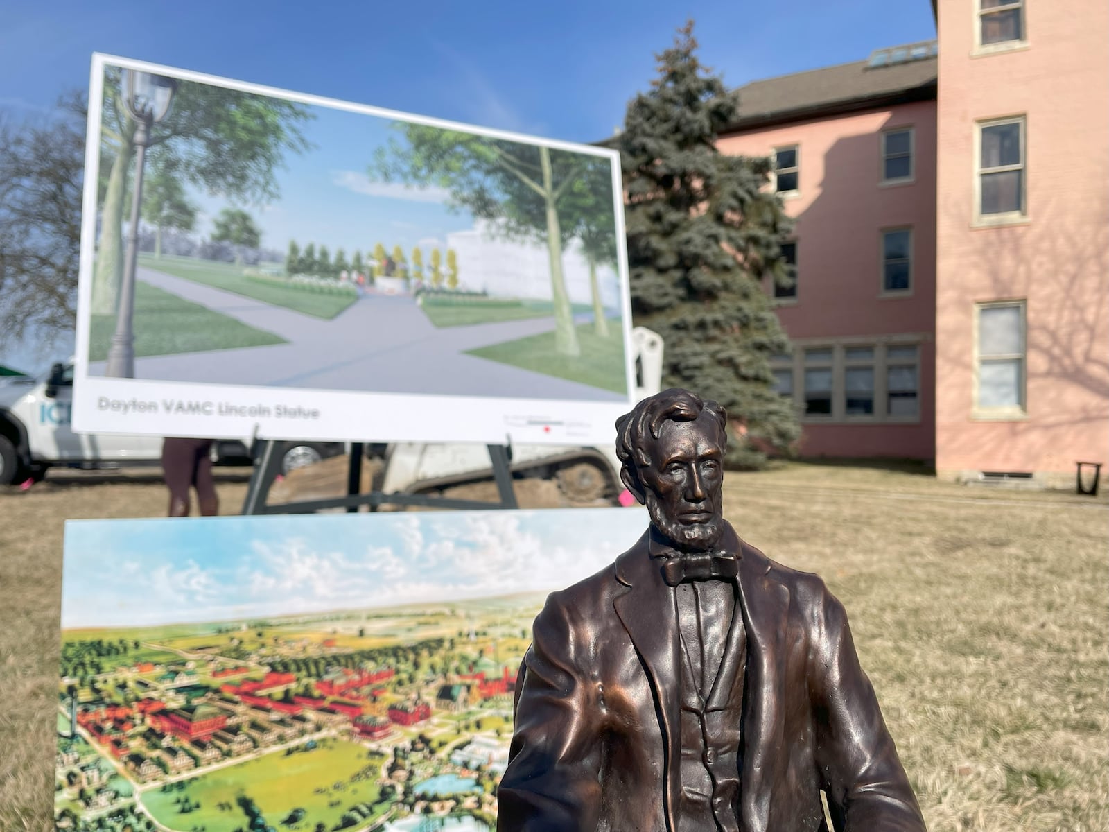 A miniature version of the Lincoln sculpture sits on a table in front of site plans for the campus' new park.