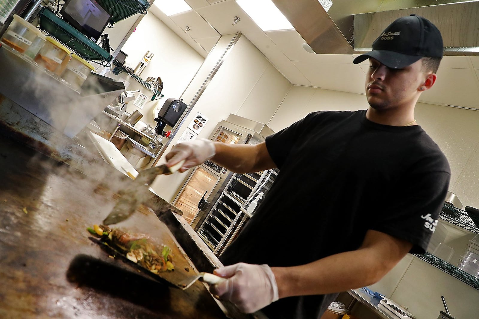 Hayden Lawhorn works the grill at Jon Smith Subs in Springfield. BILL LACKEY/STAFF