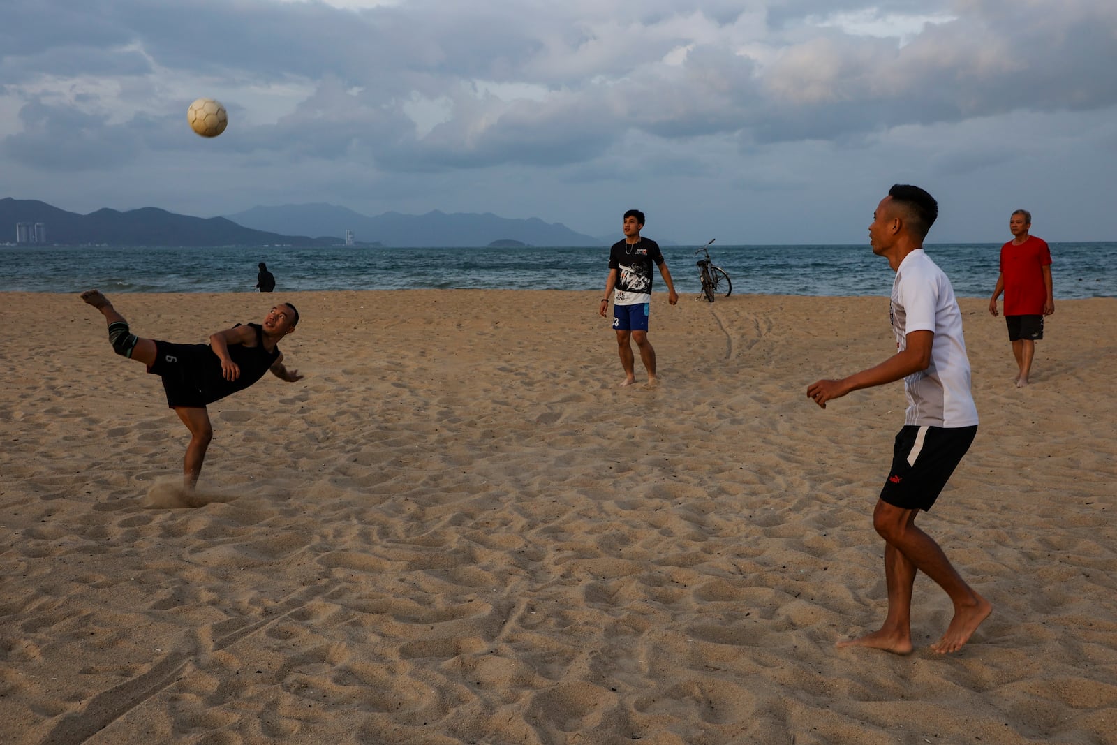 A group of men play soccer on Nha Trang's Bai Bien Beach, in Nha Trang, Vietnam on Feb. 8, 2025. (AP Photo/Yannick Peterhans)