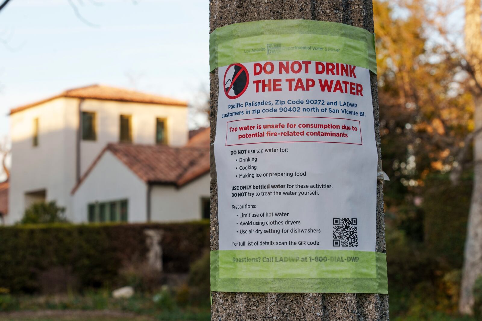 FILE - A sign posted by the Los Angeles Department of Water and Power reads: "Do not drink the tap water," as President Donald Trump tours the Palisades Fire zone damage in the Pacific Palisades neighborhood of Los Angeles, Jan. 24, 2025. (AP Photo/Damian Dovarganes, File)