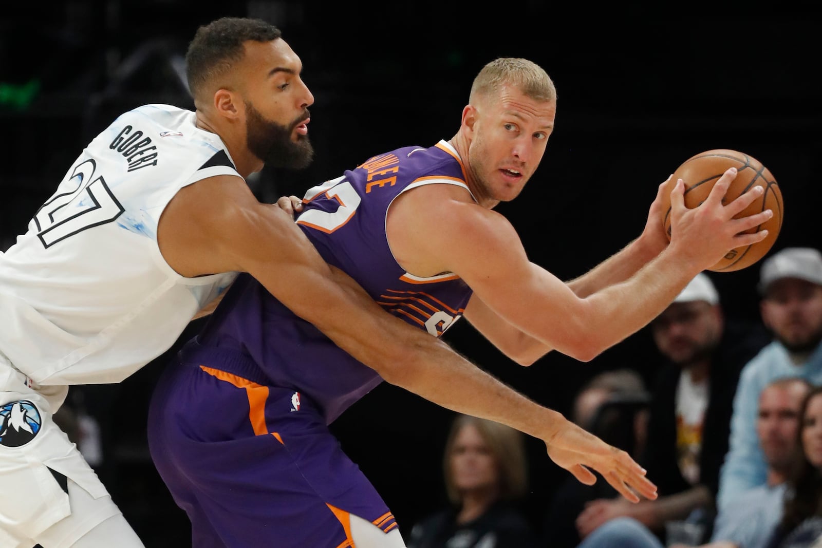 Phoenix Suns center Mason Plumlee, right, keeps the ball away from the defense of Minnesota Timberwolves center Rudy Gobert (27) in the first quarter of an NBA basketball game Sunday, Nov. 17, 2024, in Minneapolis. (AP Photo/Bruce Kluckhohn)